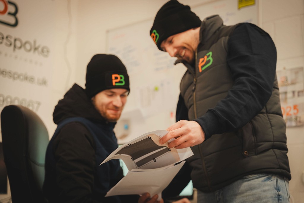 two men looking at room plan on paper
