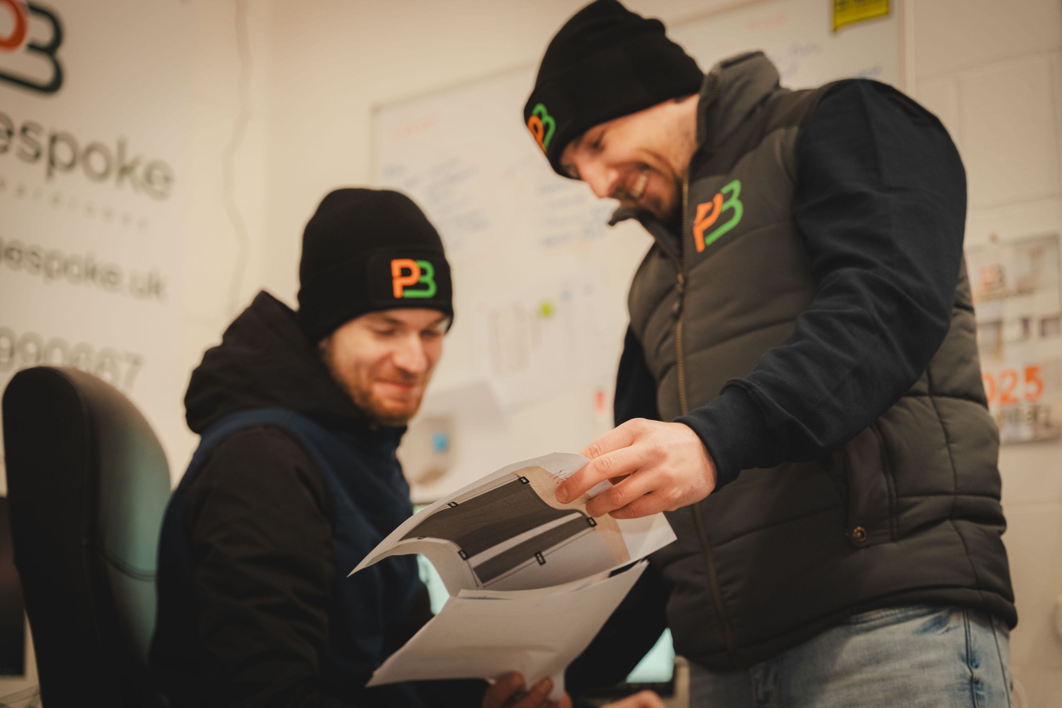 two men looking at room plan on paper