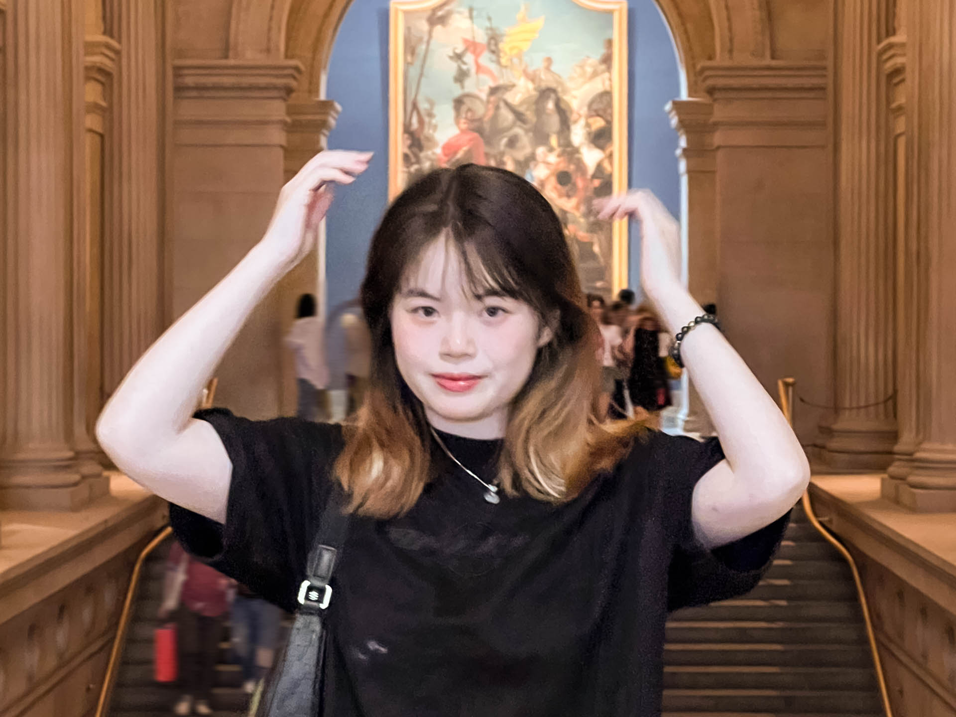 a woman in a marble room with hands above her head