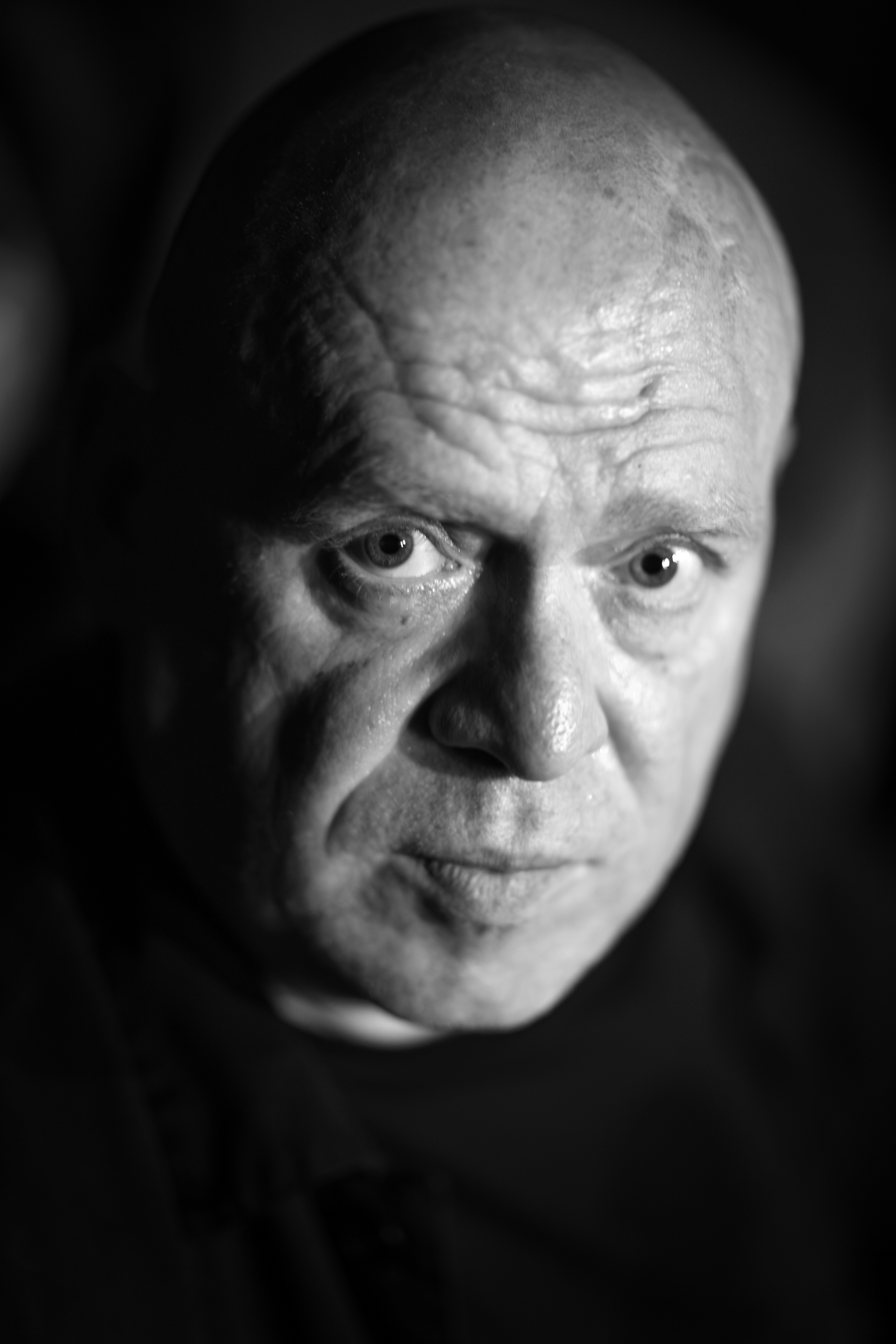 Portret łysego mężczyzny patrzącego powarznie w górę.