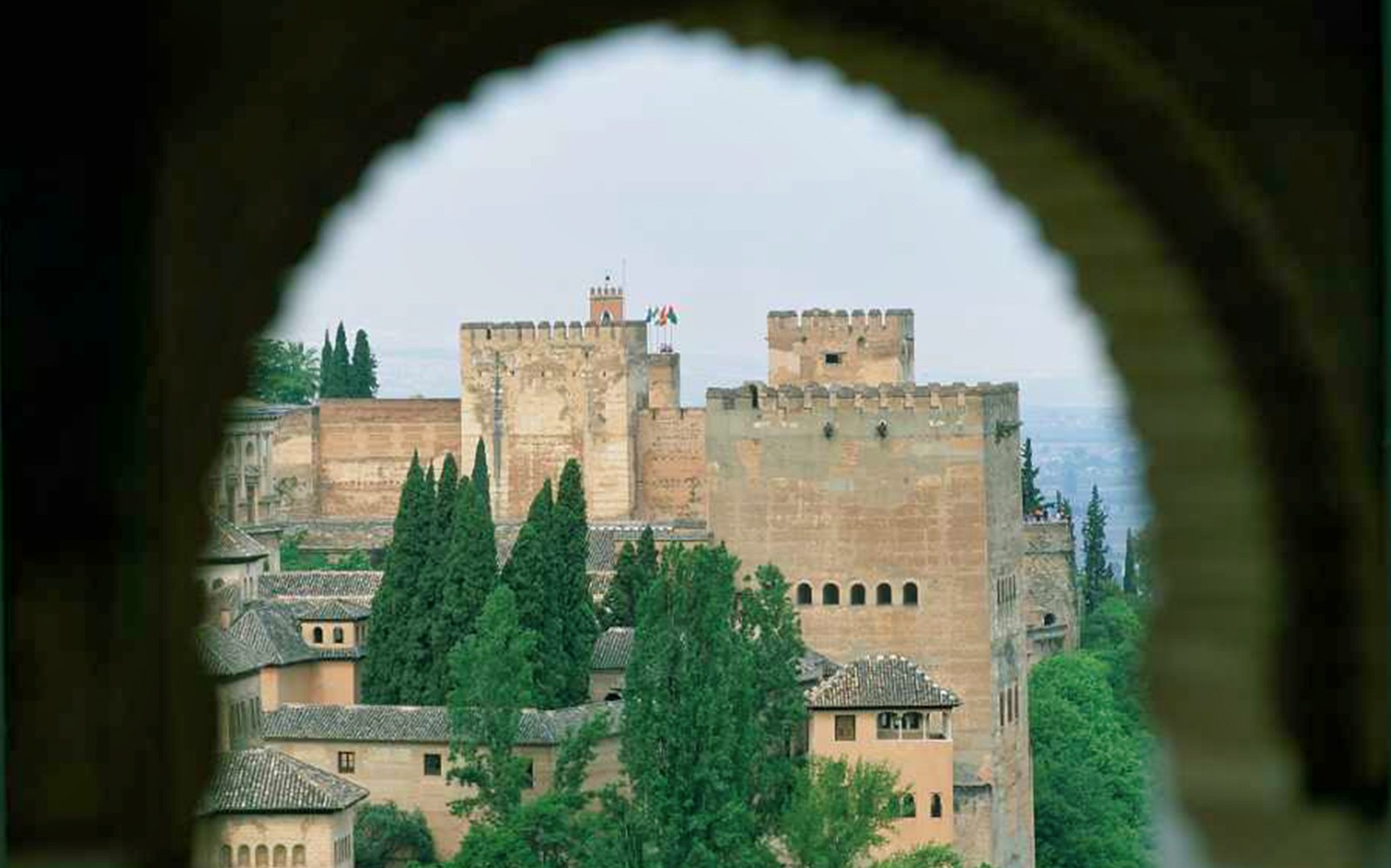 Utsikt over Alhambra-festningen gjennom buegangen, Granada, Spania.
