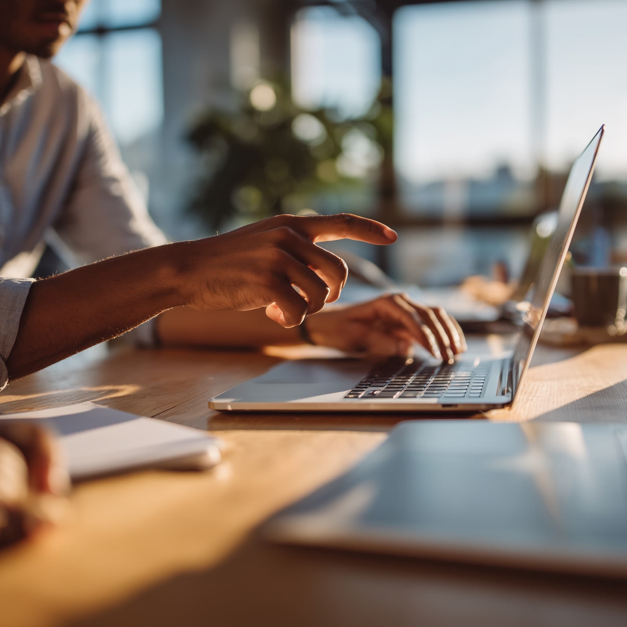 Photo de deux personnes pointant un écran d'ordinateur