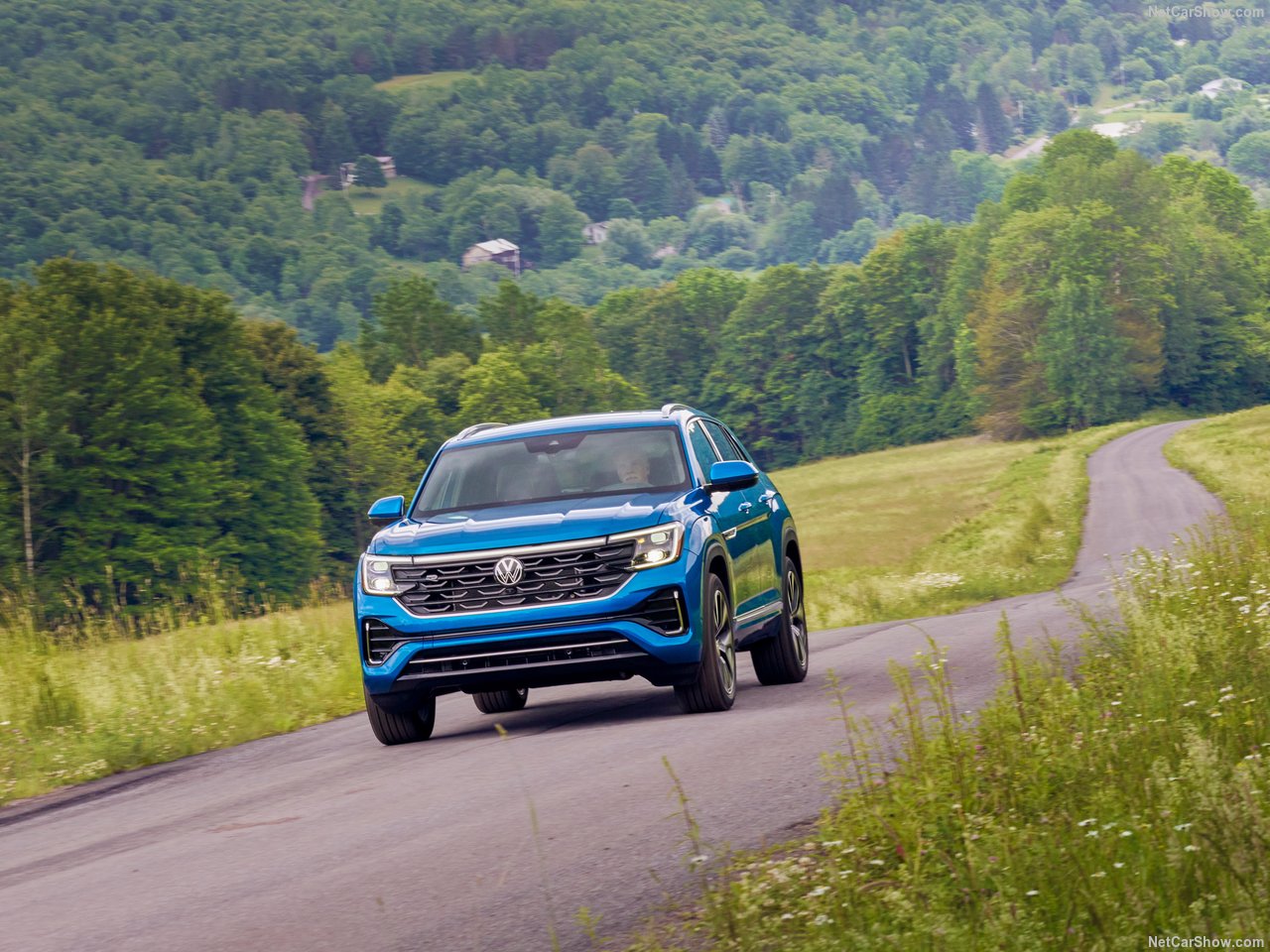 Volkswagen Atlas Cross Sport driving on a rural road surrounded by green landscape