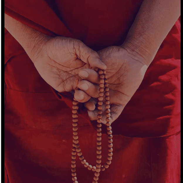 monk holds mala, retreat india