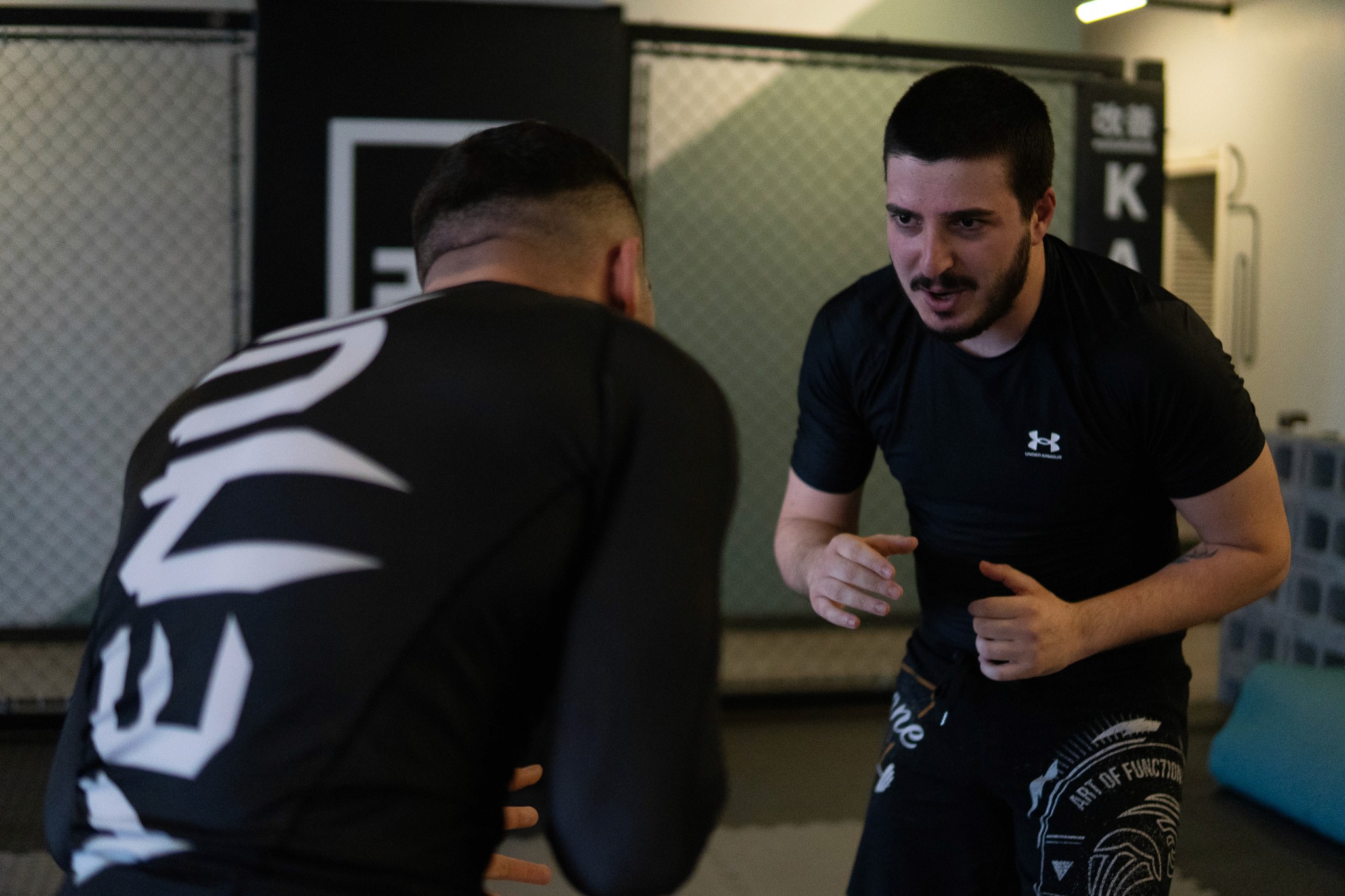 photo of two students standing trying to engage hand fight