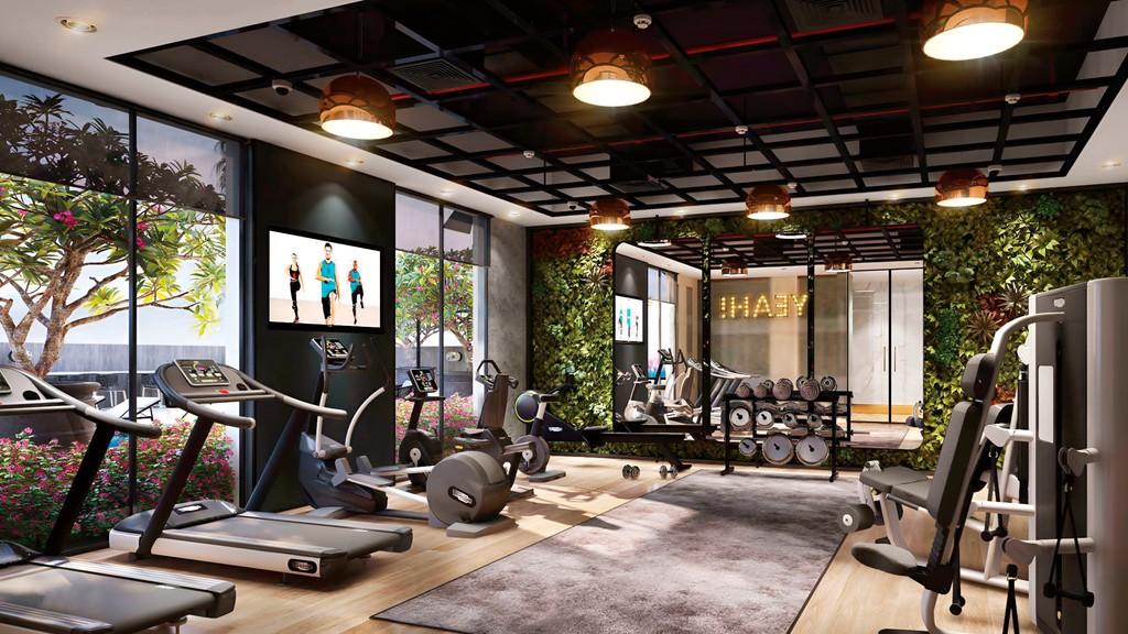 A gym room featuring a large window and a treadmill, with natural light illuminating the space.