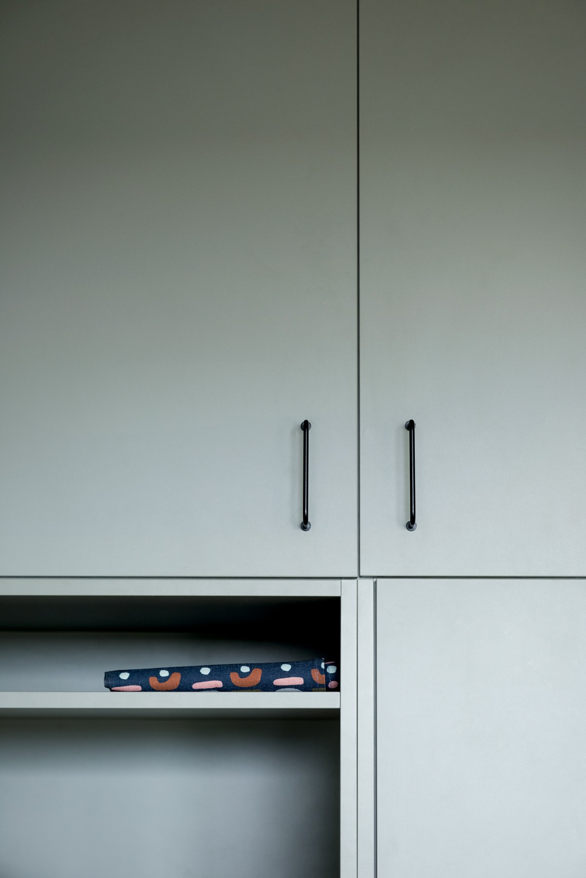 Cabinetry storage detail at Glenhaven Kitchen, highlighting muted green joinery, open niches, and integrated handles.