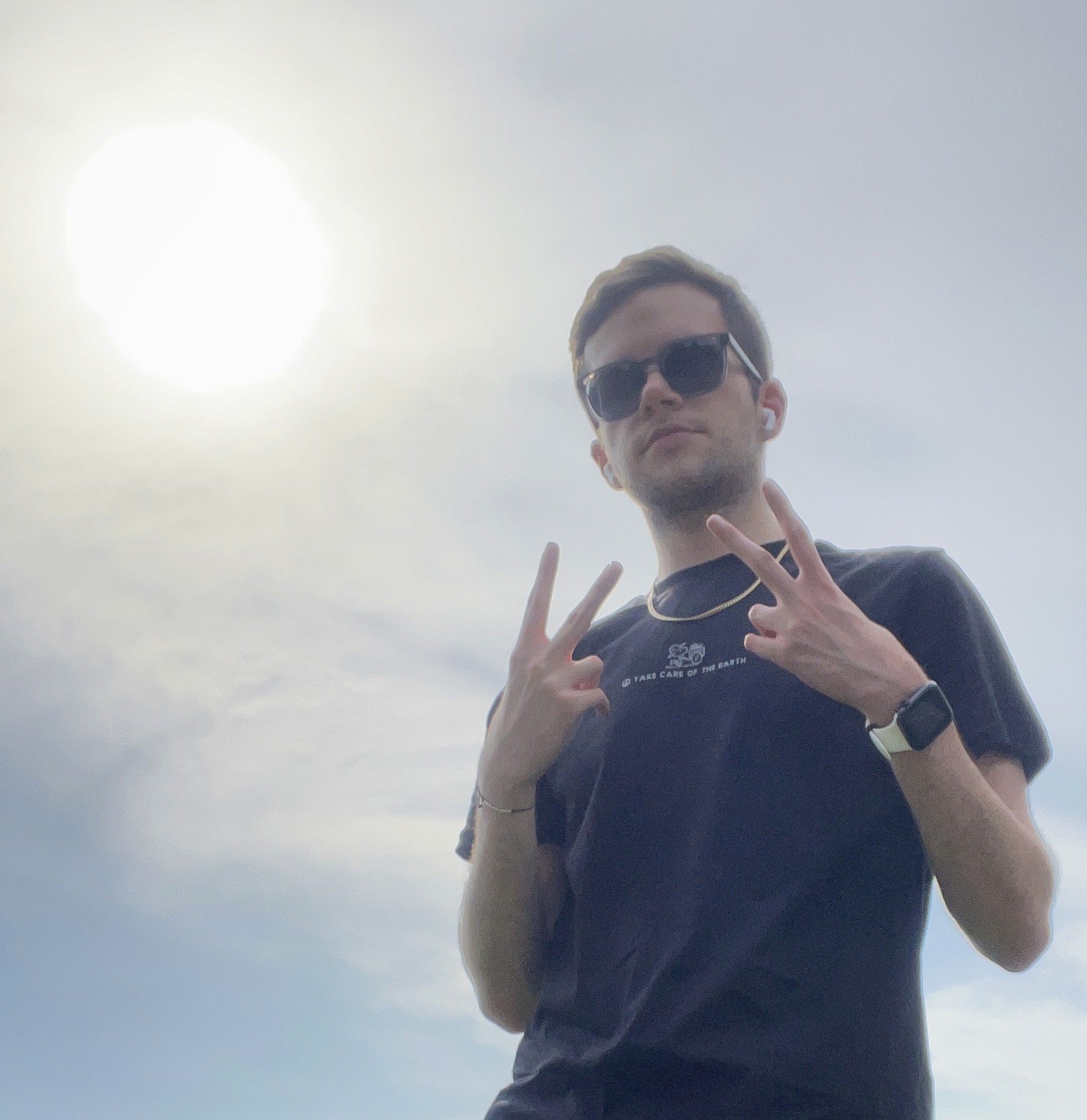 Brandon posing for picture. He is wearing a black t-shirt and sunglasses.
