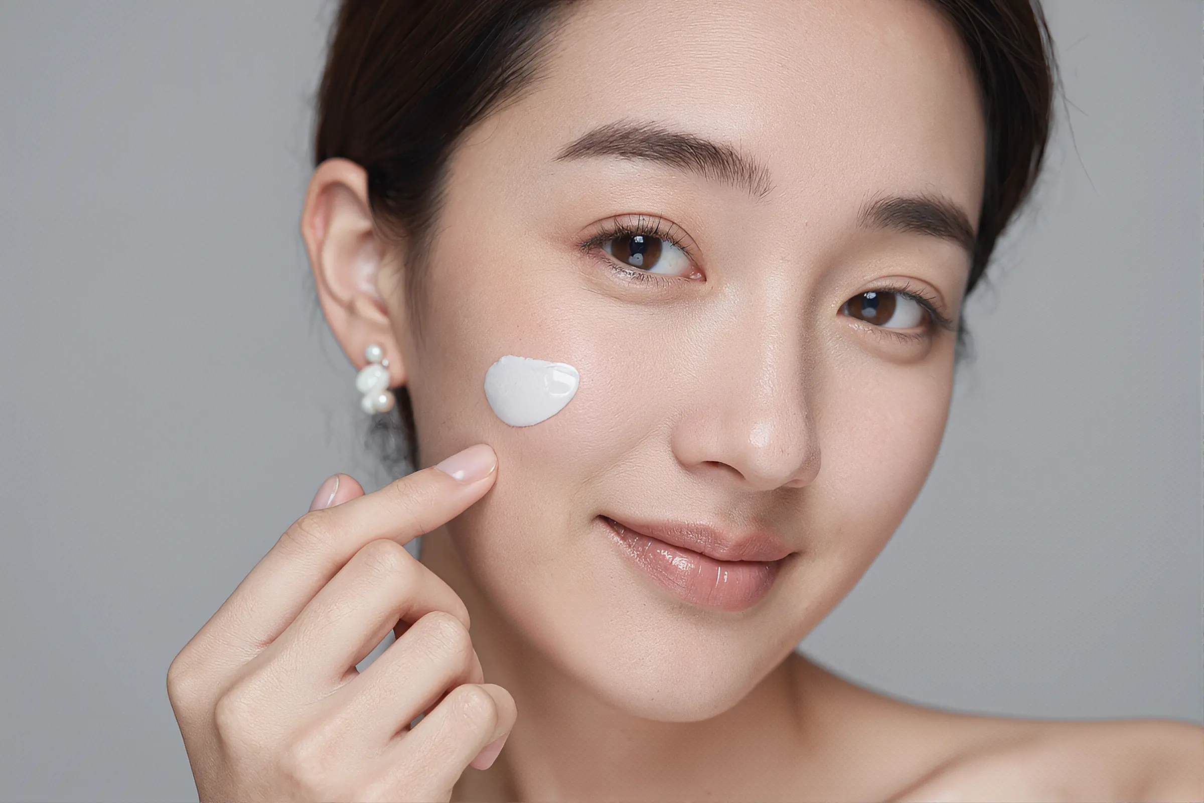Woman applying cream on her face