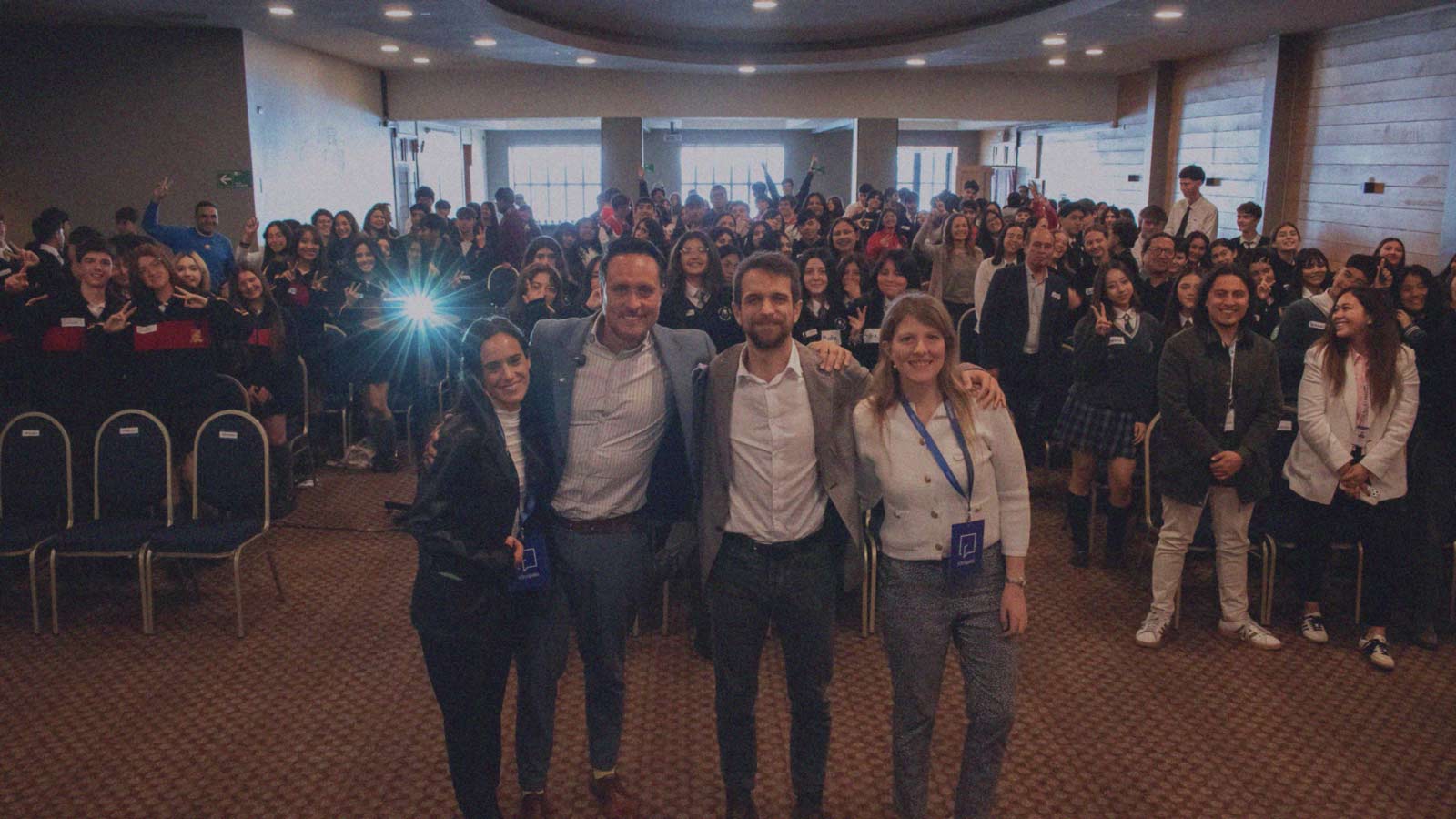 Foto del equipo IdeaPaís Los Lagos junto a los alcaldes de Puerto Montt y Puerto Varas, mientras de fondo posan estudiantes que participaron en la primera edición del Encuentro de Líderes Jóvenes (ELIJO) que se realiza en la Región de Los Lagos.