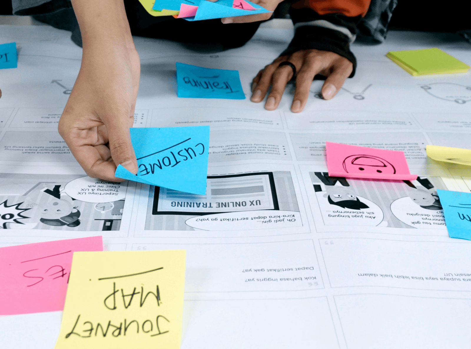 A close-up of a woman sitting on the floor in a stockroom, using a barcode scanner on a package.