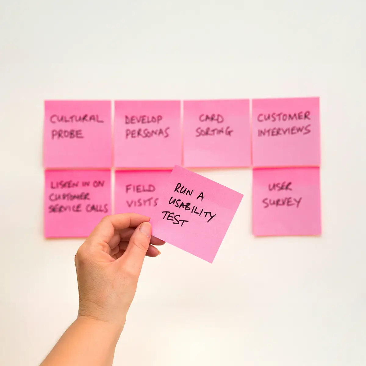image of post it notes depecting user testing, with the text mainly out of focus but one post it note sharply in focus with the text "run a usability test"