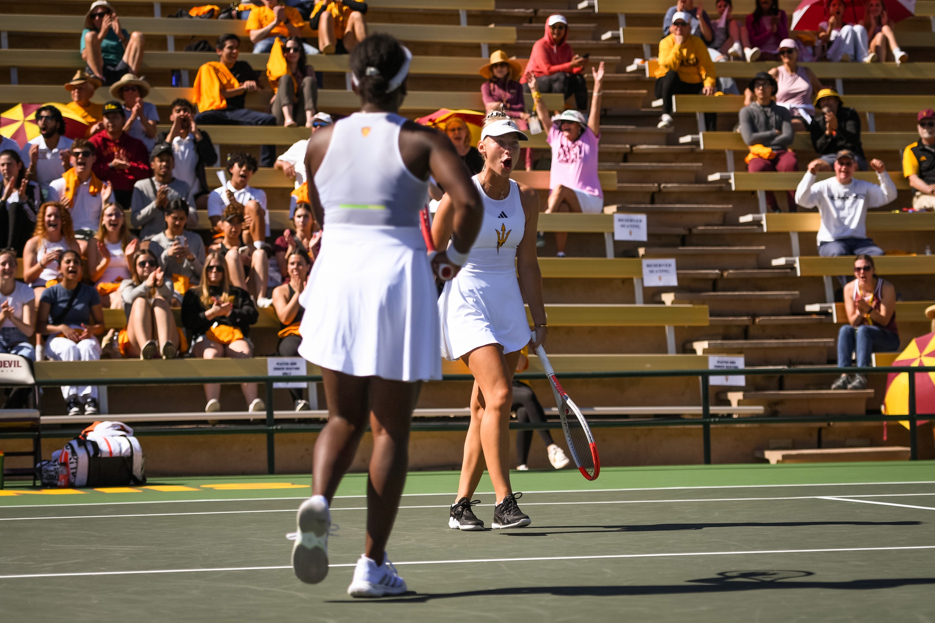 Arizona State Women's tennis players celebrating after winning point