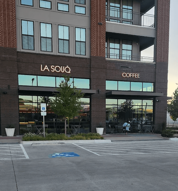 La Souq Coffee storefront with illuminated exterior signage on brick building façade.