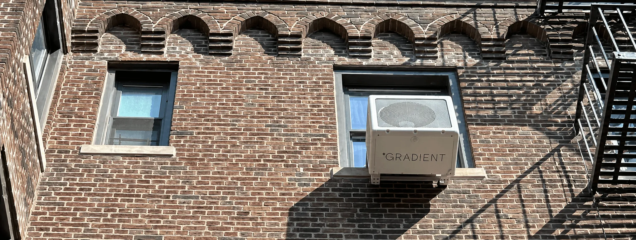 Gradient heat pump on a brick apartment exterior