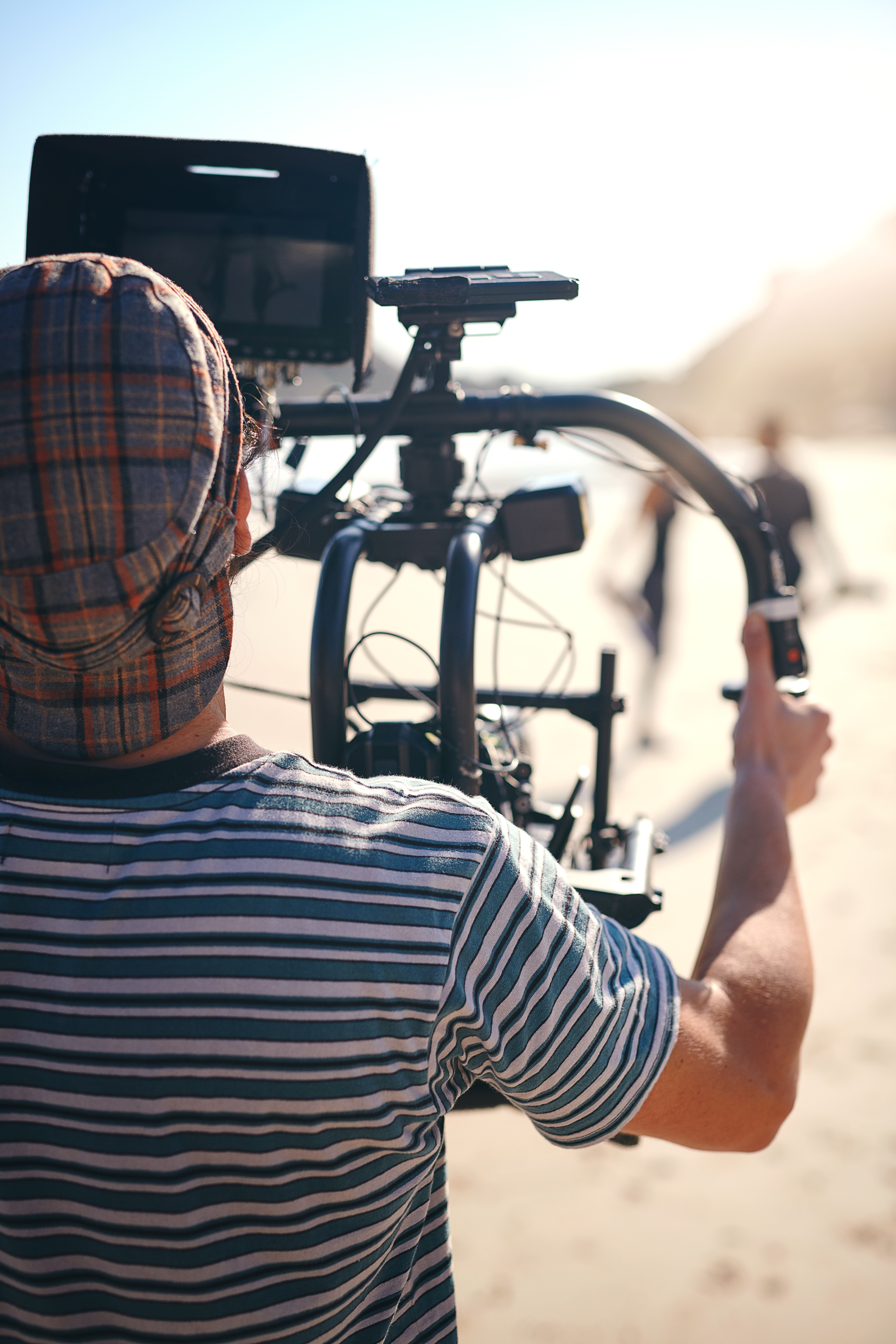 Modern minimalist hallway with colorful abstract art gallery wall, tan leather sofa, and floating staircase leading to natural light