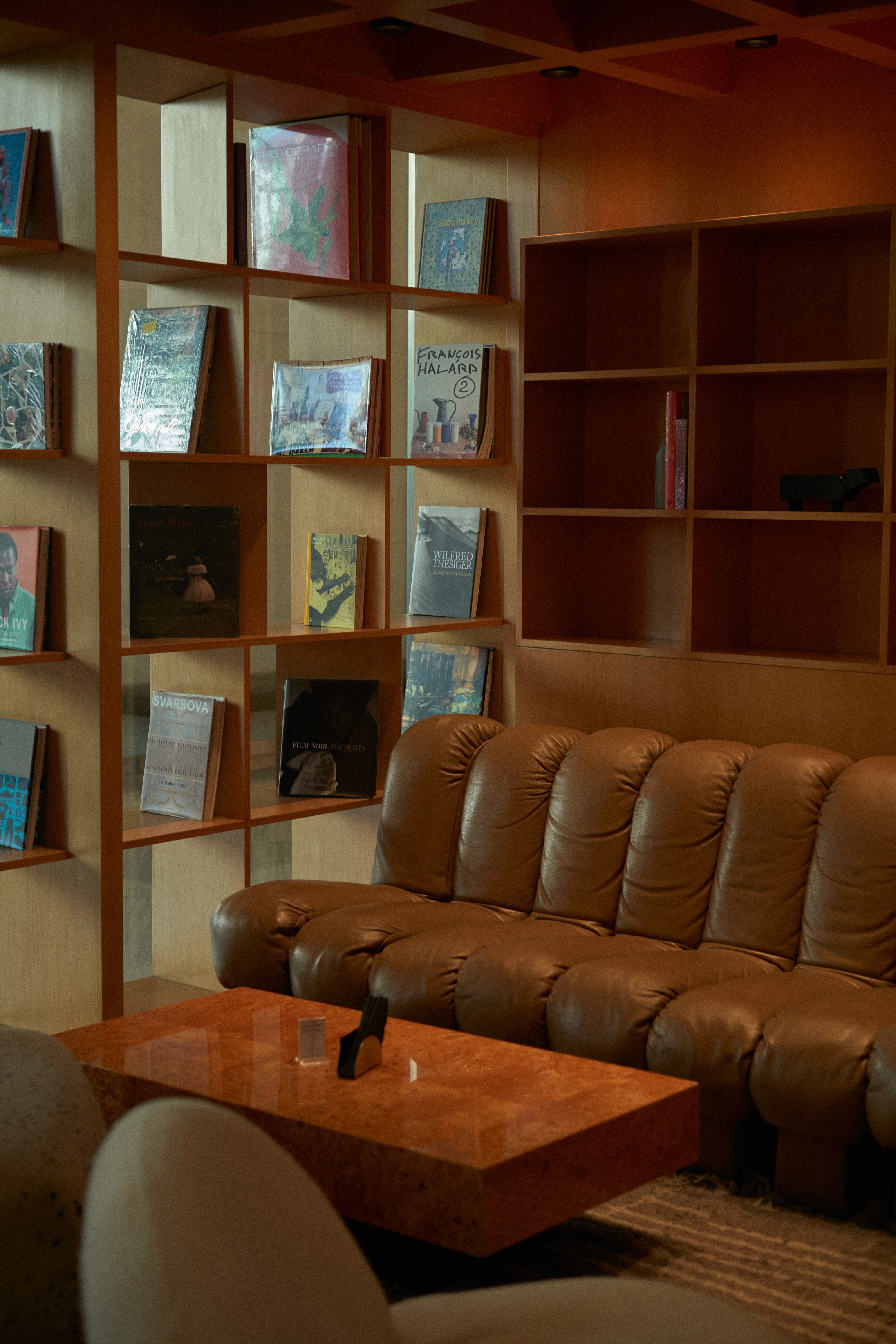 View of the French countryside through a stone villa’s open living room, with sofas and trees framing the scene