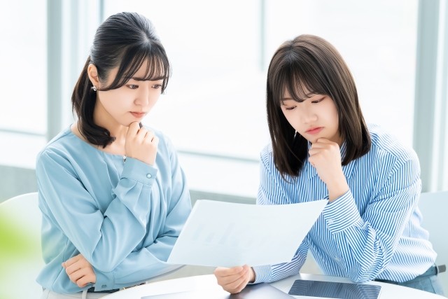資料を見ながら考える2人の女性