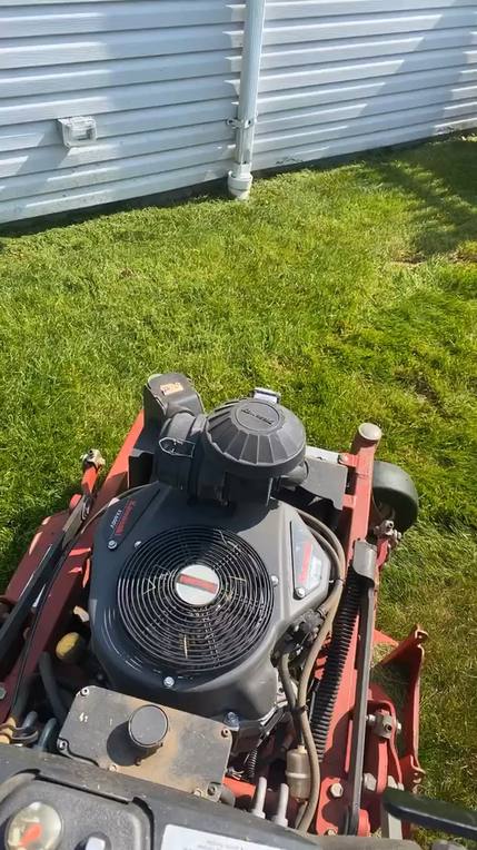 Ride on mower cutting a green residential lawn