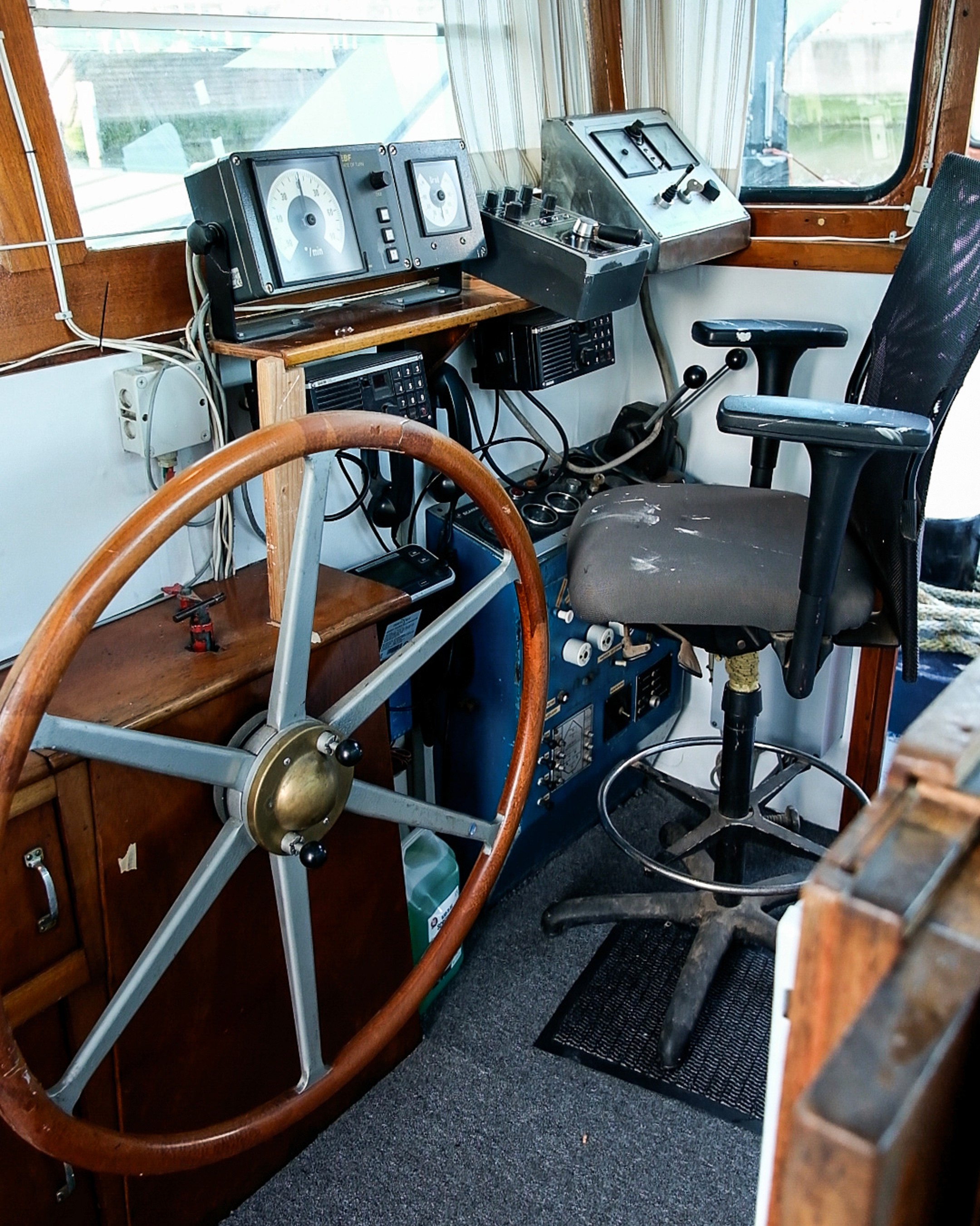 Modern living room with purple sofa, colorful rug, and open shelving