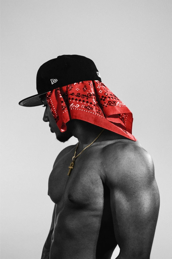 Black and white studio portrait in profile, cap and red bandana