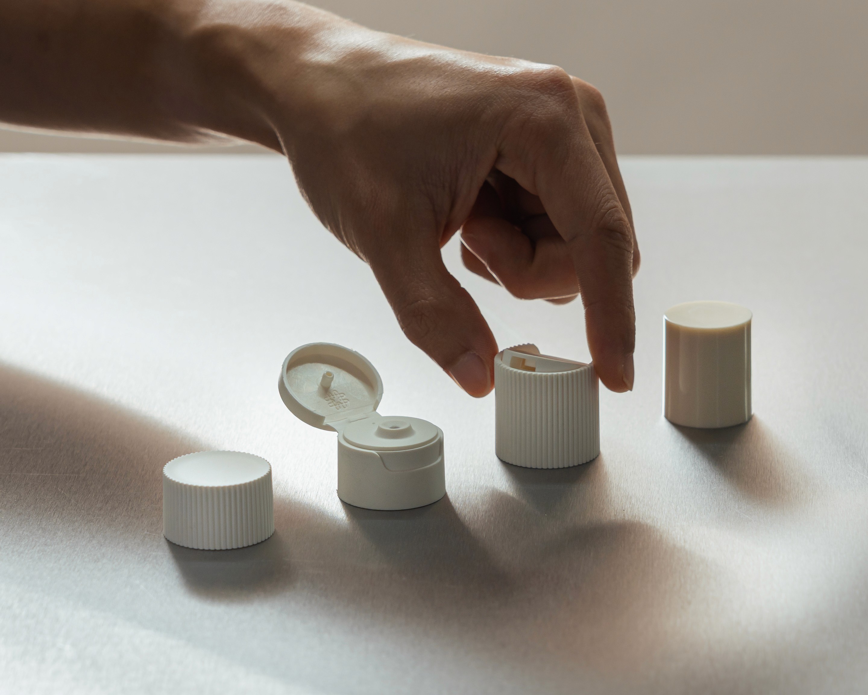 An assortment of precision-engineered VIVOMER threaded closures, caps, and lids. These durable, plastic-free cosmetic closures offer a seamless fit for retail packaging, allowing brands to transition to microplastic-free components without compromising on seal integrity or aesthetic finish.