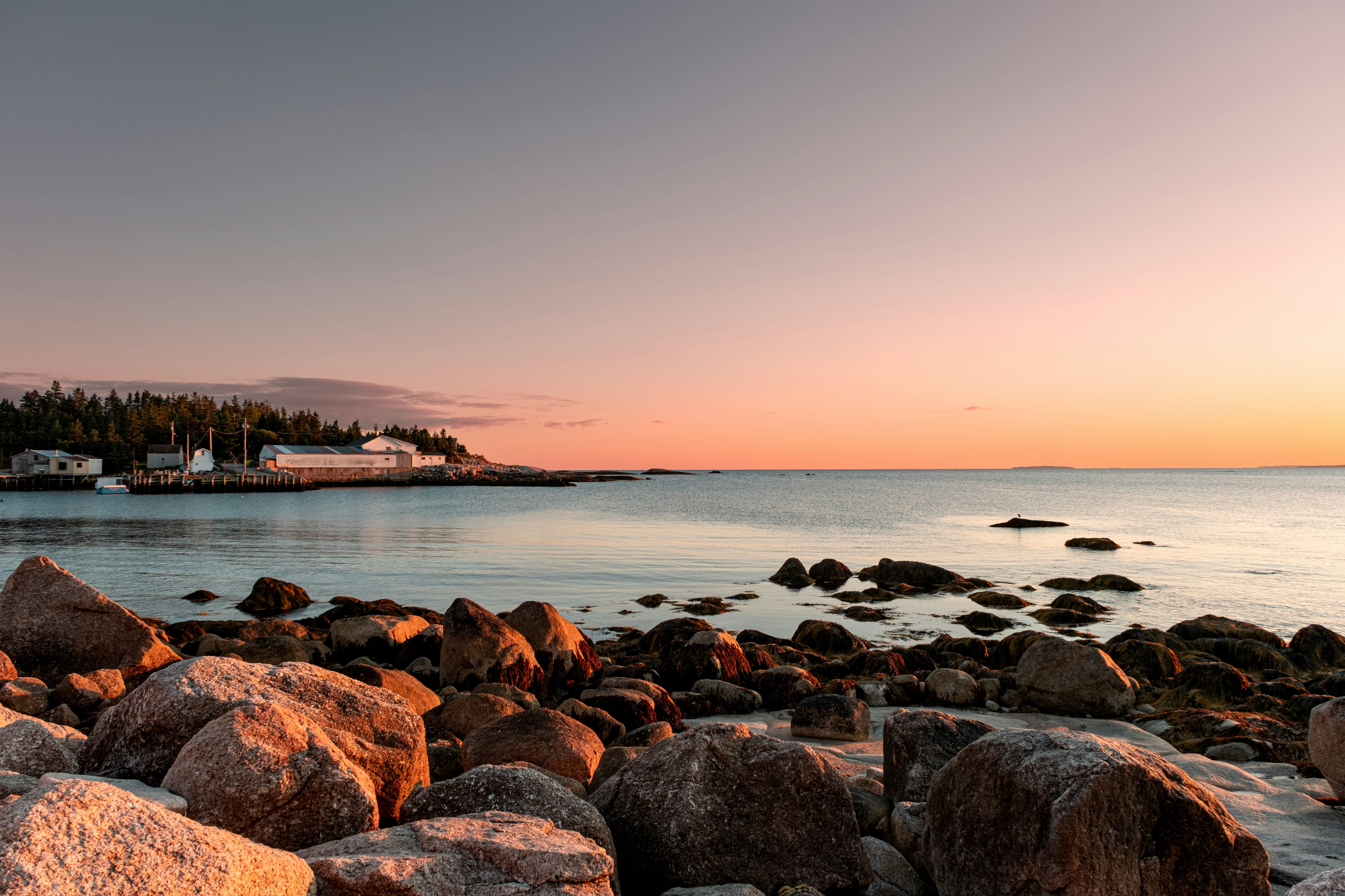 Rocky coastline at sunset with calm ocean waters