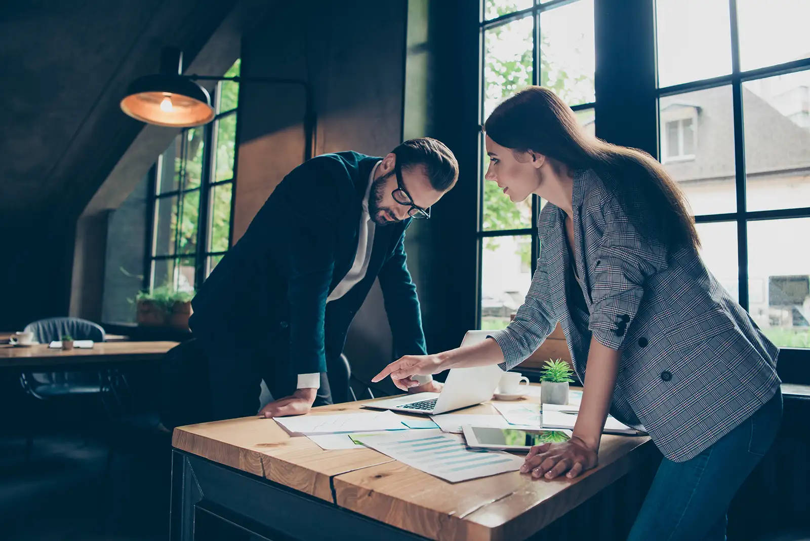 Business partners standing over a table reviewing documents