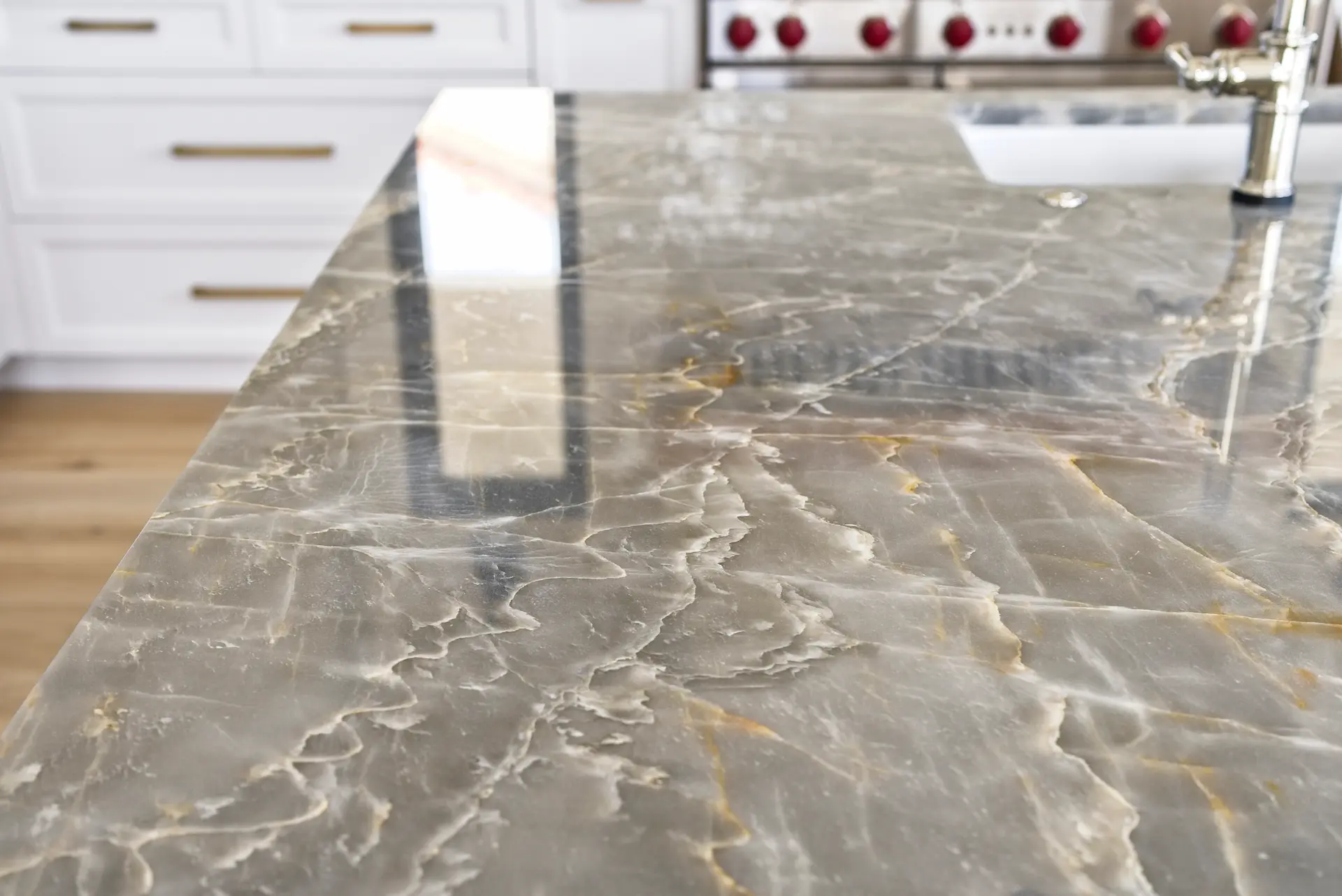 Close-up of the stunning quartzite kitchen island countertop, showcasing the exquisite material choice and craftsmanship in the Dana Point Full Remodel. Photo by Todd Huge.