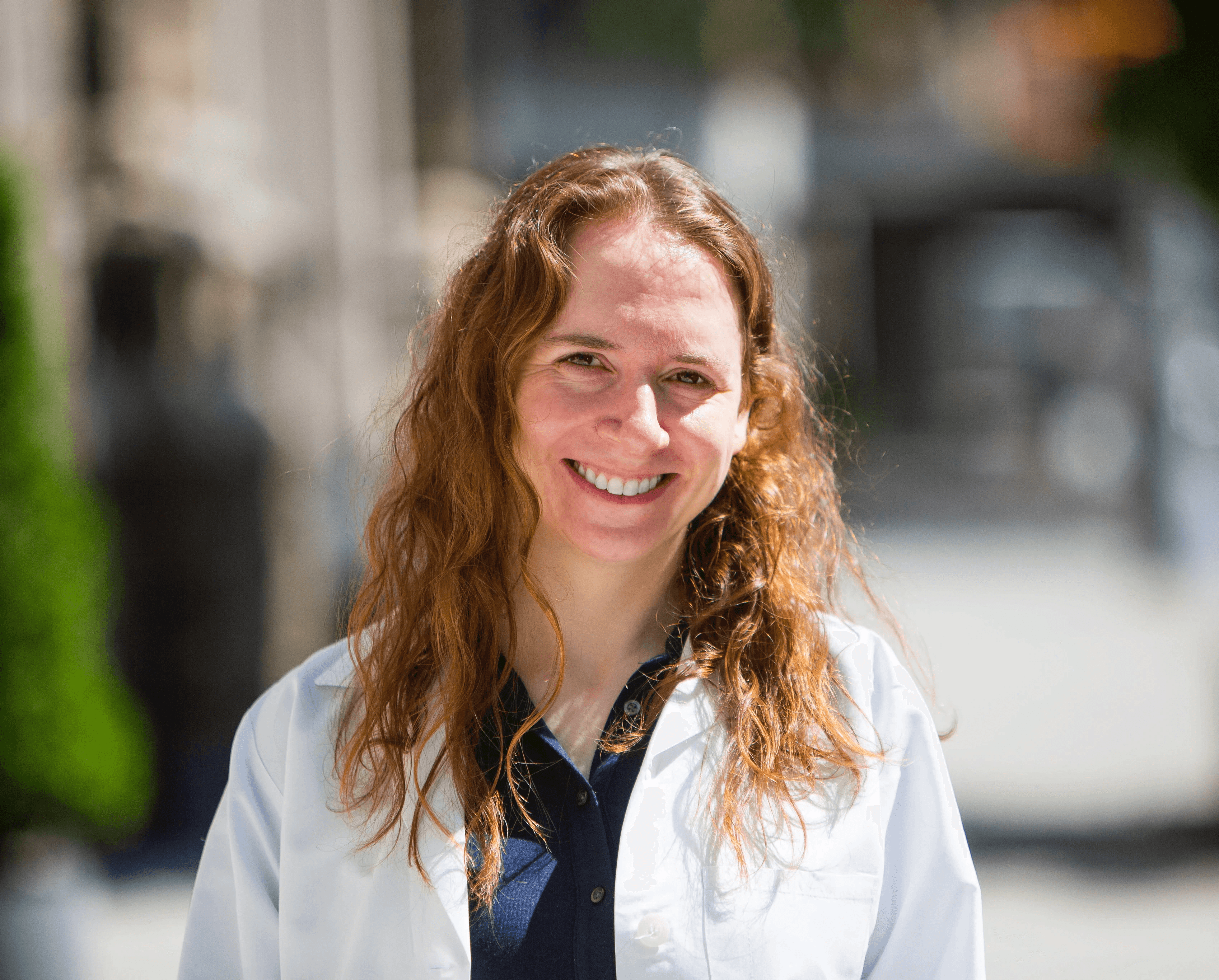 Portrait of a woman with long red hair gently touching her face, looking into the camera