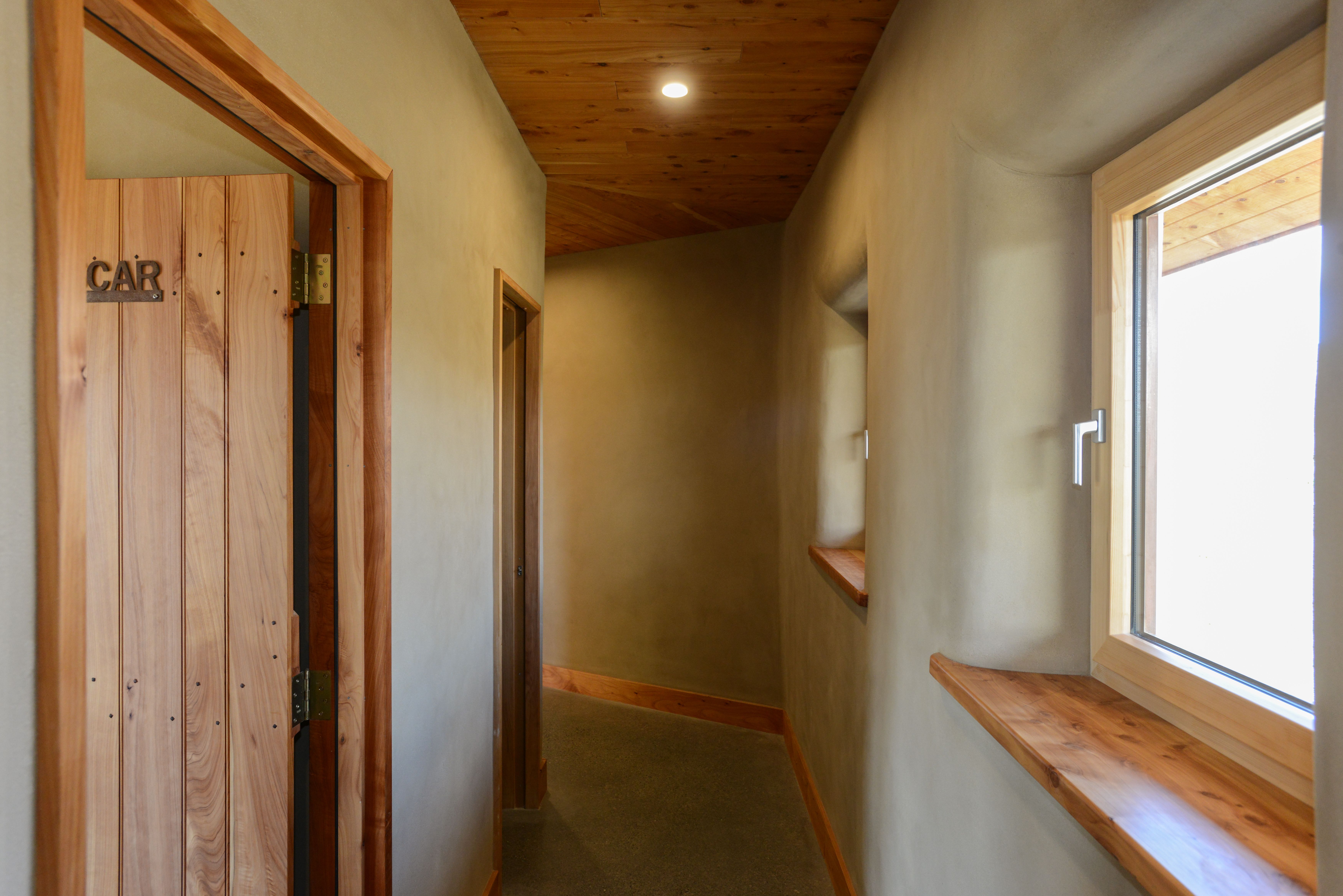 Natural clay plastered interior hallway, timber doors and feature timber trims