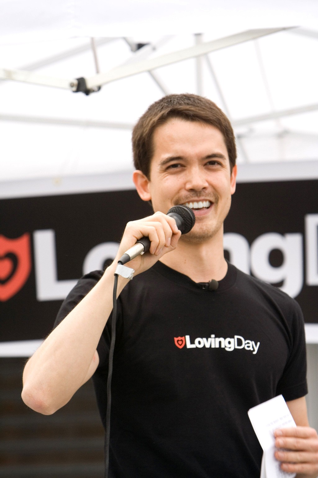  Loving Day Founder Ken Tanabe holding a microphone and wearing a Loving Day t-shirt