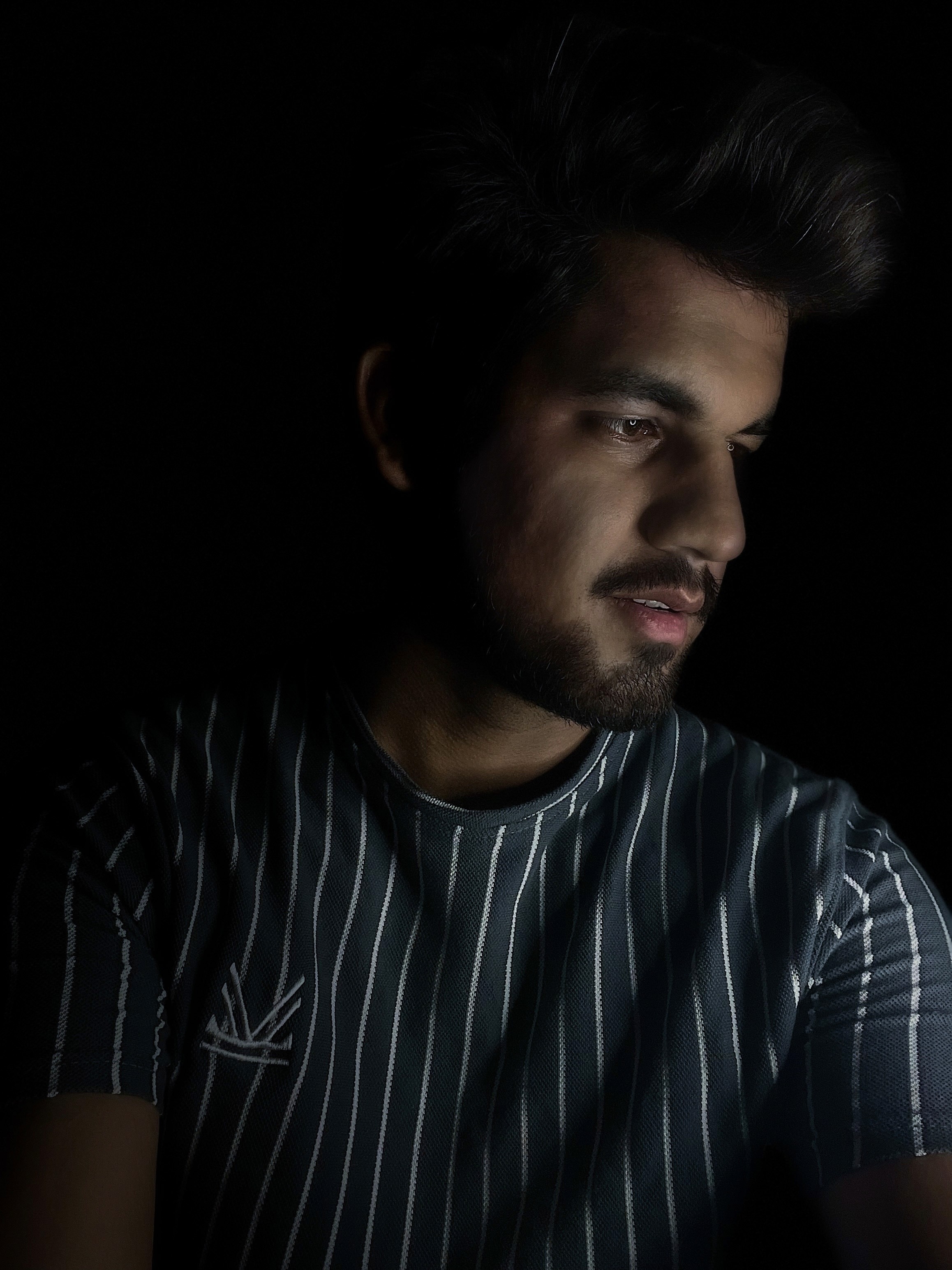 A person in a winter coat and furry hat walking along a snow-covered path through a forest of frosted trees.