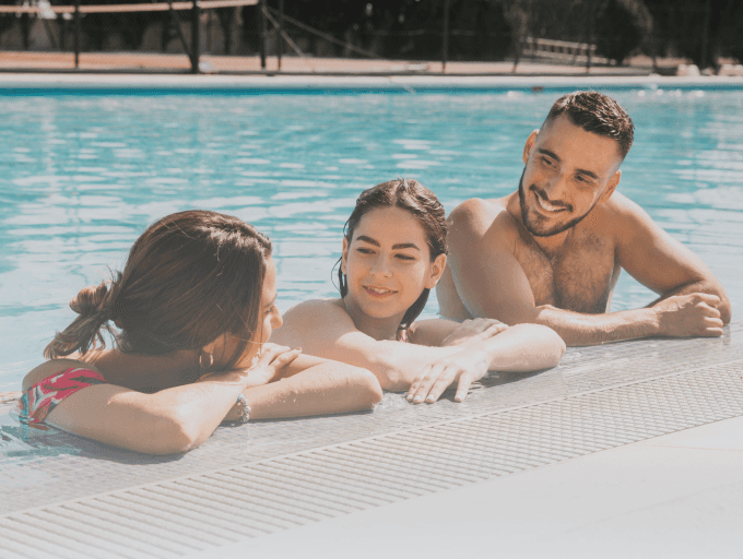 A family relaxing together in a swimming pool, enjoying warm water.