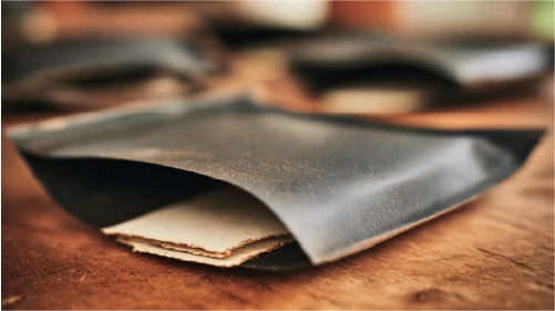 E-commerce mailer packaging nested in a dark, flexible polymer material.