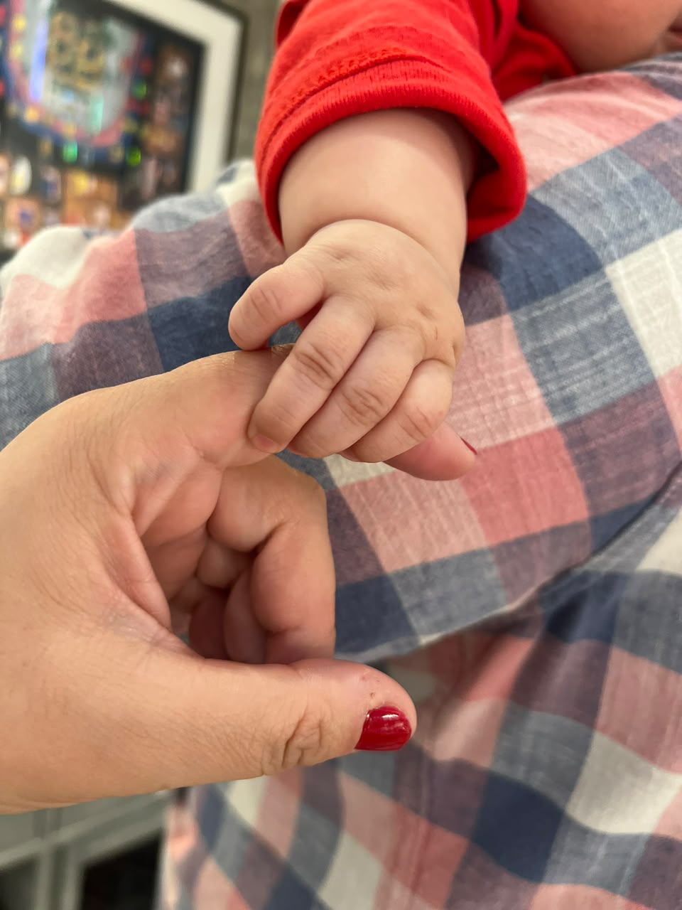 Mano de bebé sosteniendo un dedo, símbolo de familia y continuidad