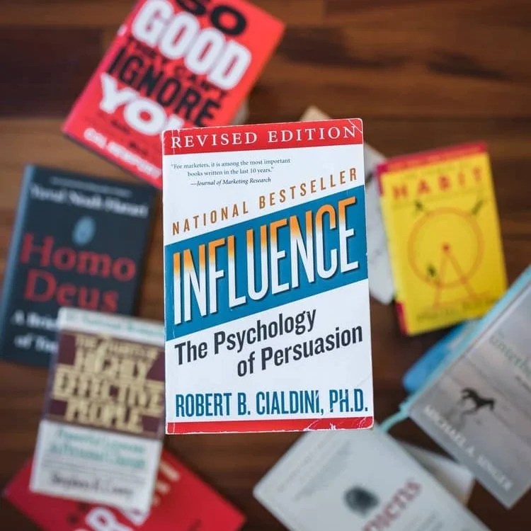 a book in focus, with the title: Influence- the psychology of persuasion. Relating to anecdotes that pursue.