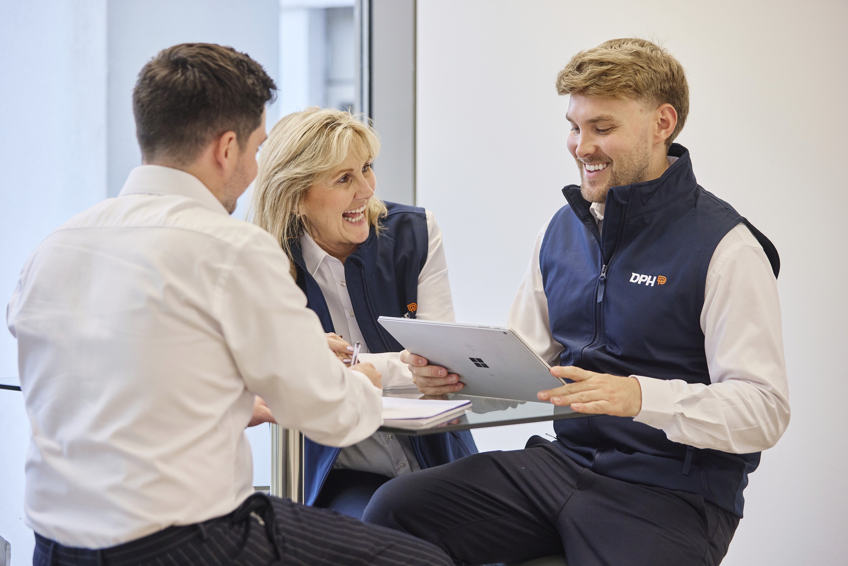 Modern building with a sleek glass facade and illuminated orange lighting, reflecting on a polished surface, creating a futuristic and elegant atmosphere