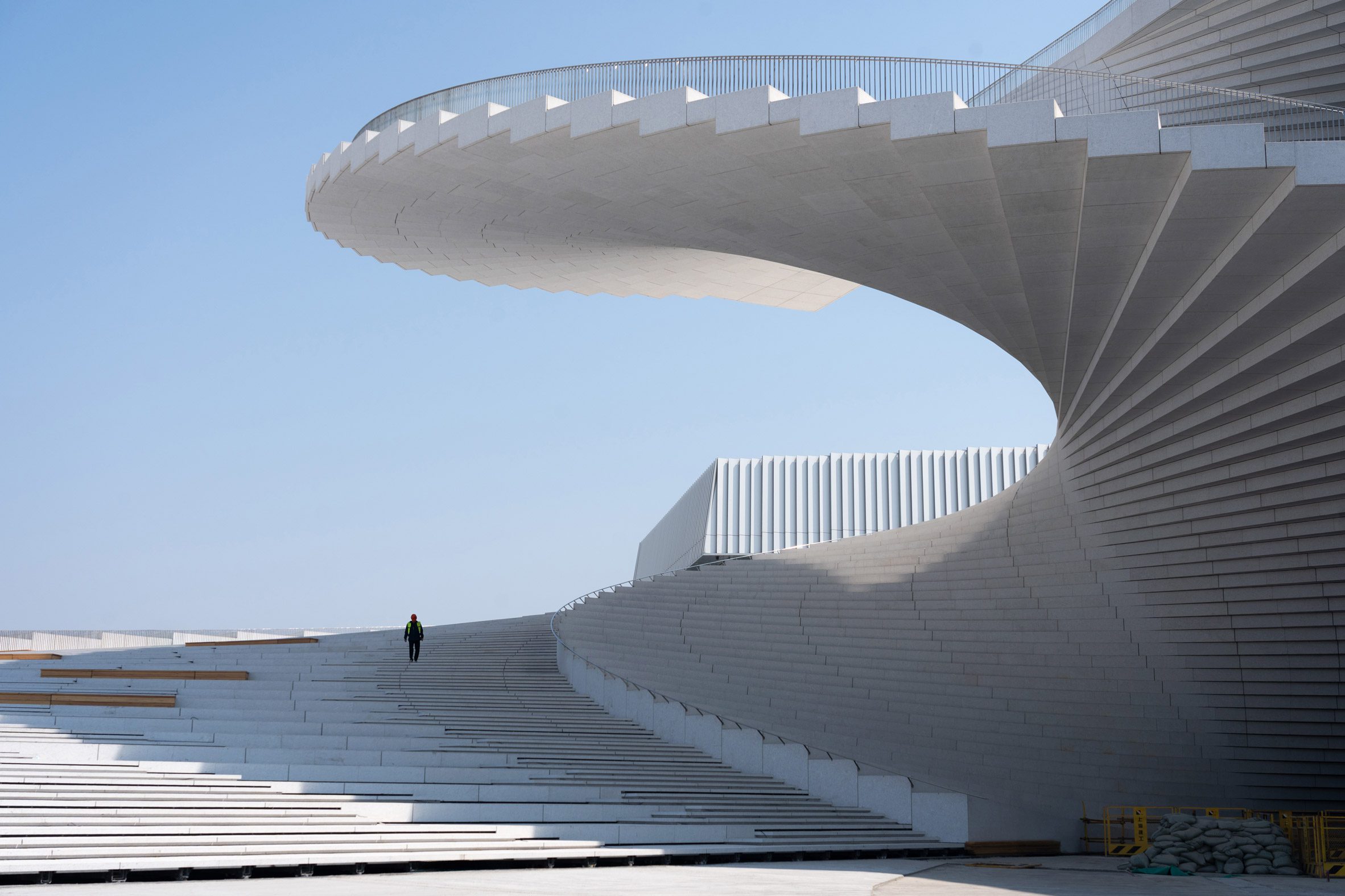 View of the French countryside through a stone villa’s open living room, with sofas and trees framing the scene