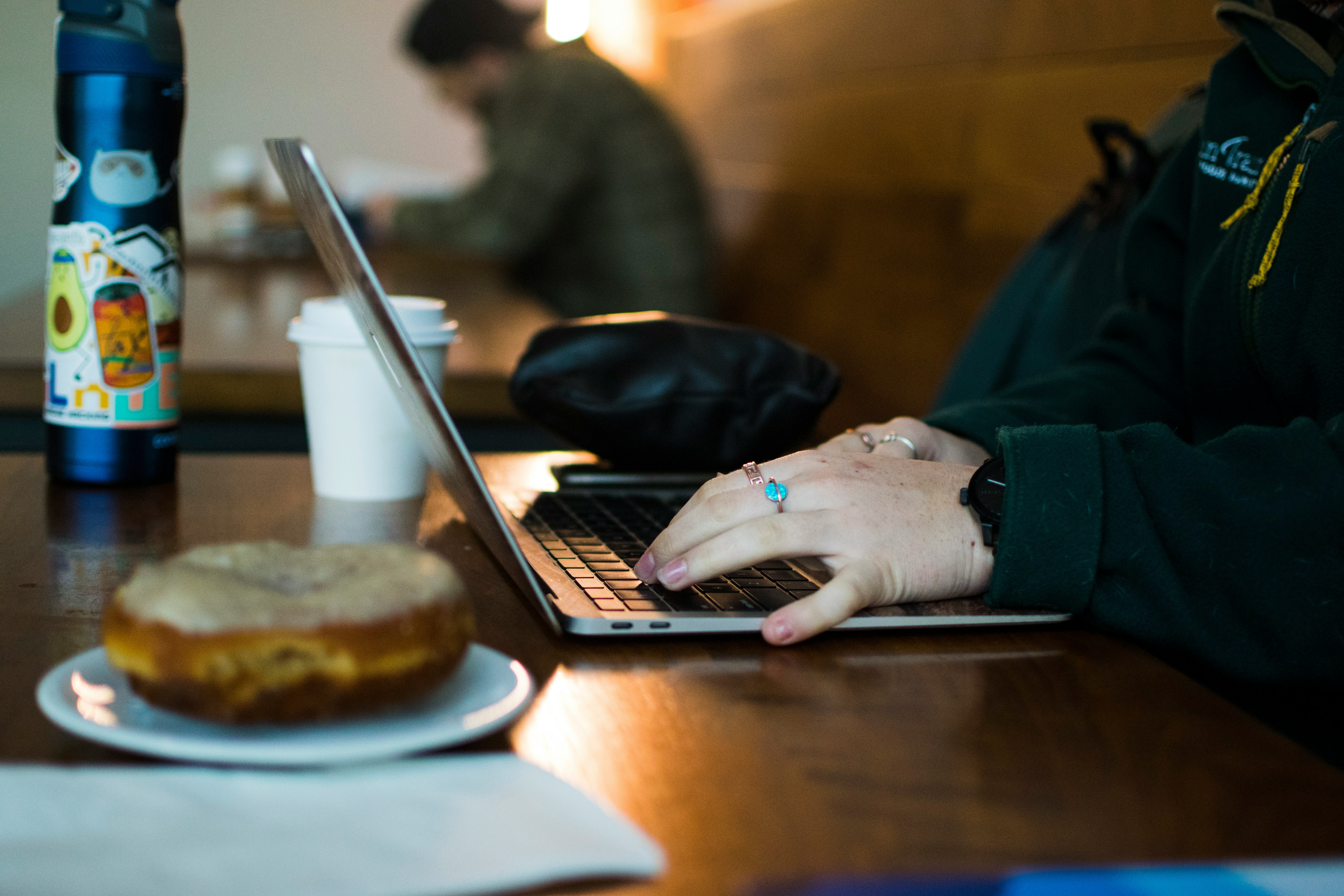 a person using a laptop on a wooden table