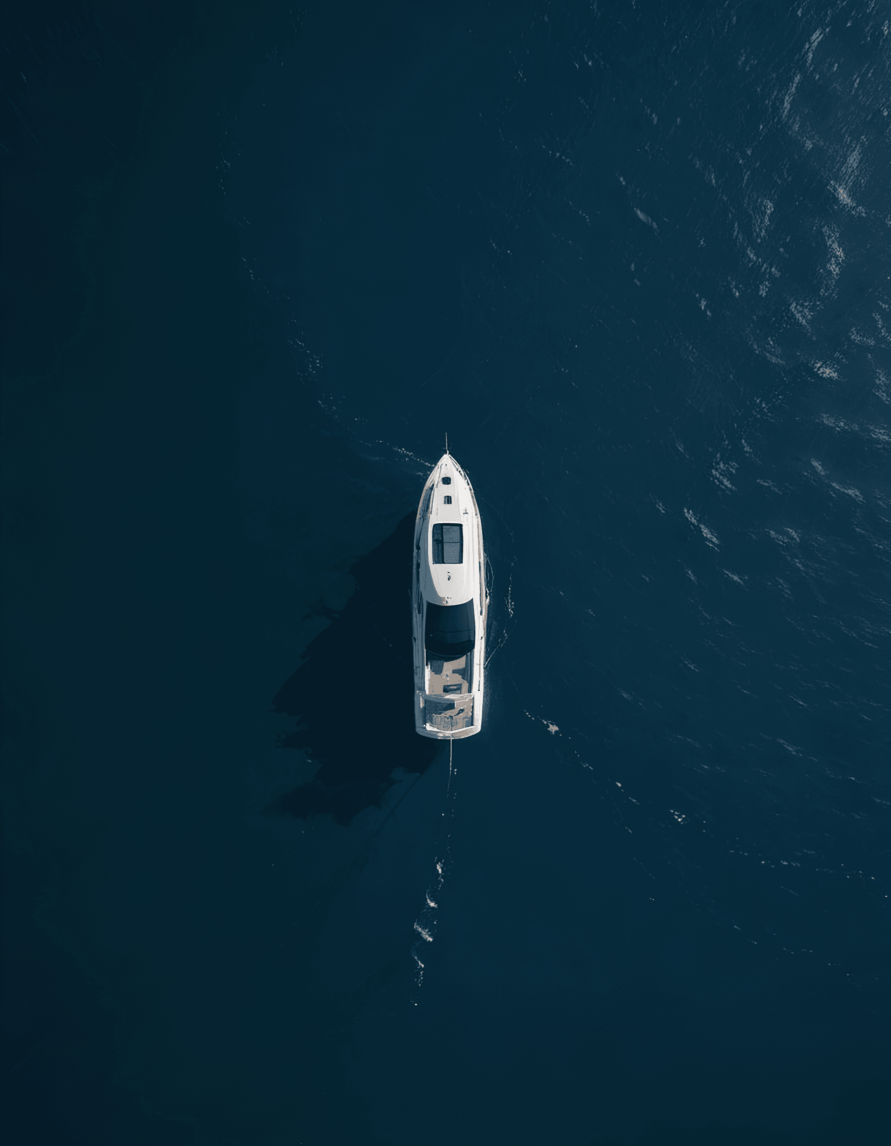 Vue aérienne d’un vaste océan bleu avec un petit bateau au loin