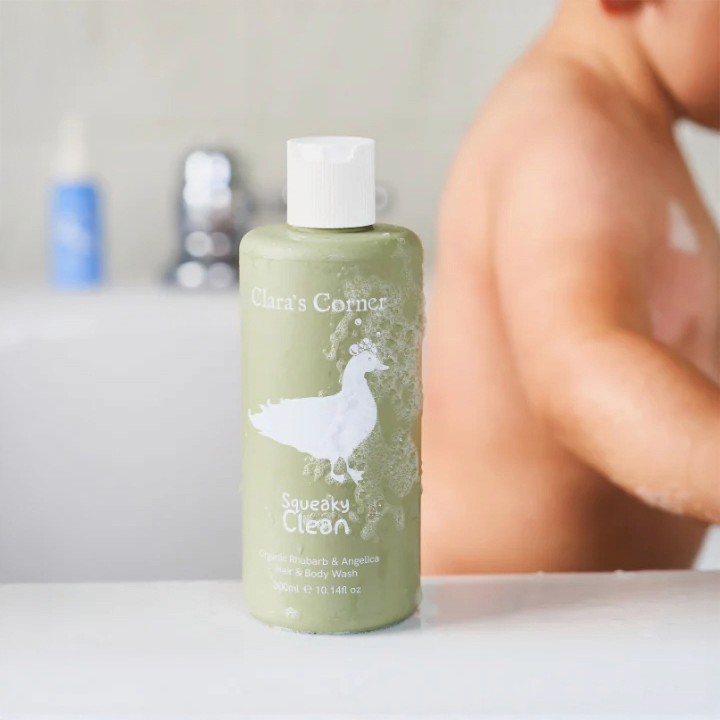 A bathtub lifestyle setting featuring Clara's Corner hair and body wash in a 300ml VIVOMER bottle. The shatterproof and water-stable biomaterial is ideal for humid shower and bath environments.