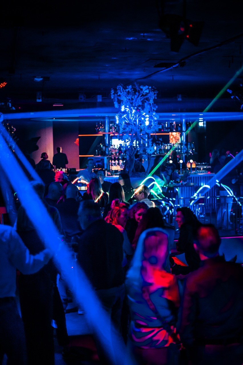 nightclub with blue lights and people dancing