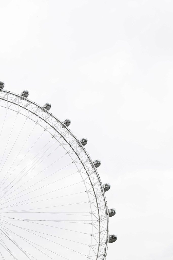 black white image showing the top right part of a ferris wheel.