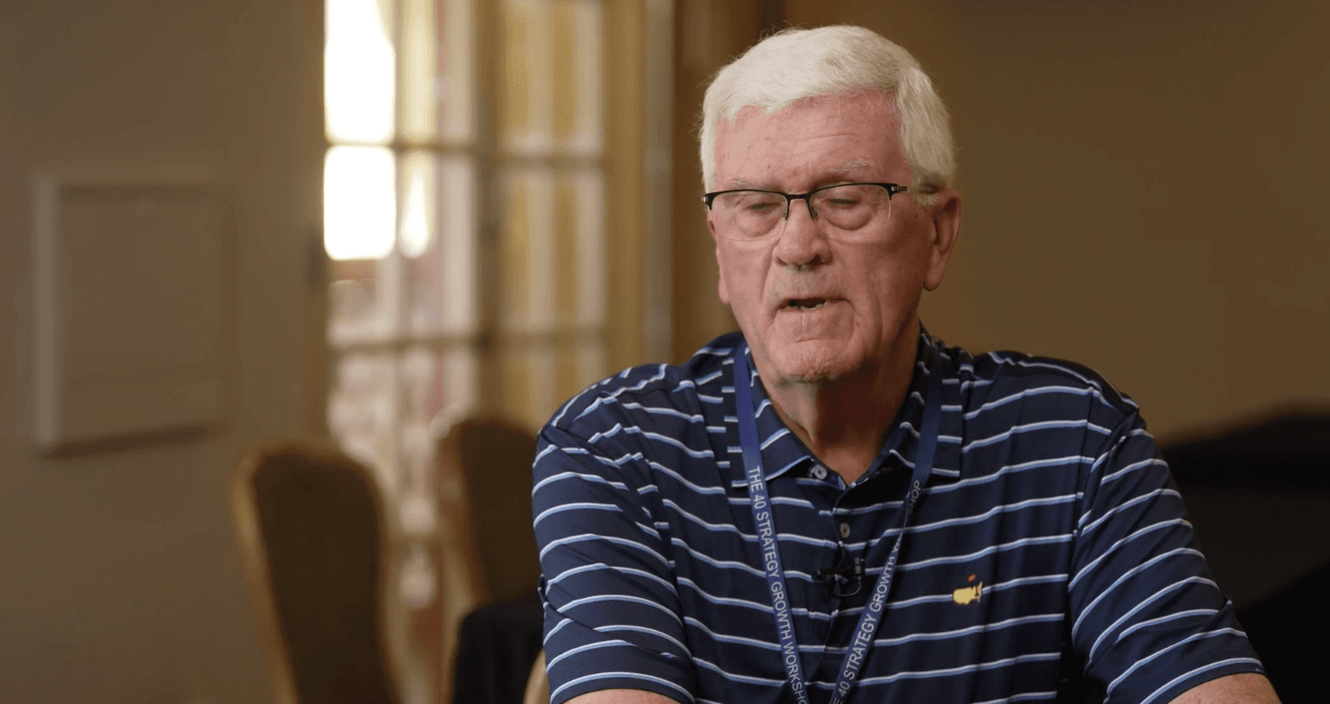 Man with beard in a red shirt smiling indoors