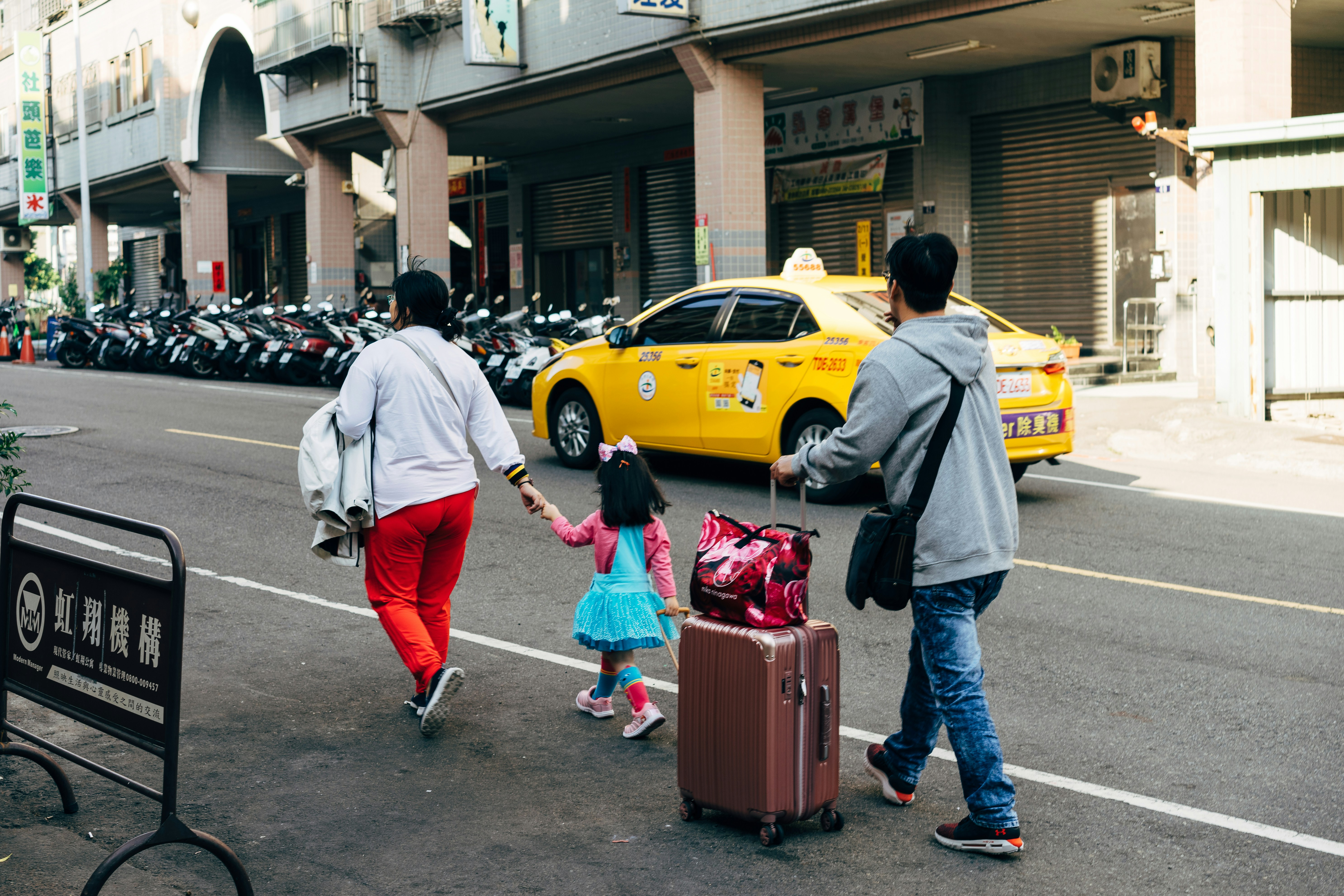 tourist family walks down street with luggage