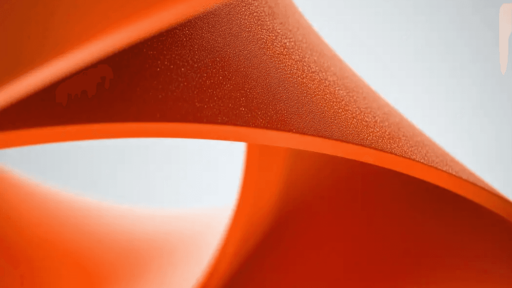Close-up of a curved orange object with a textured surface.