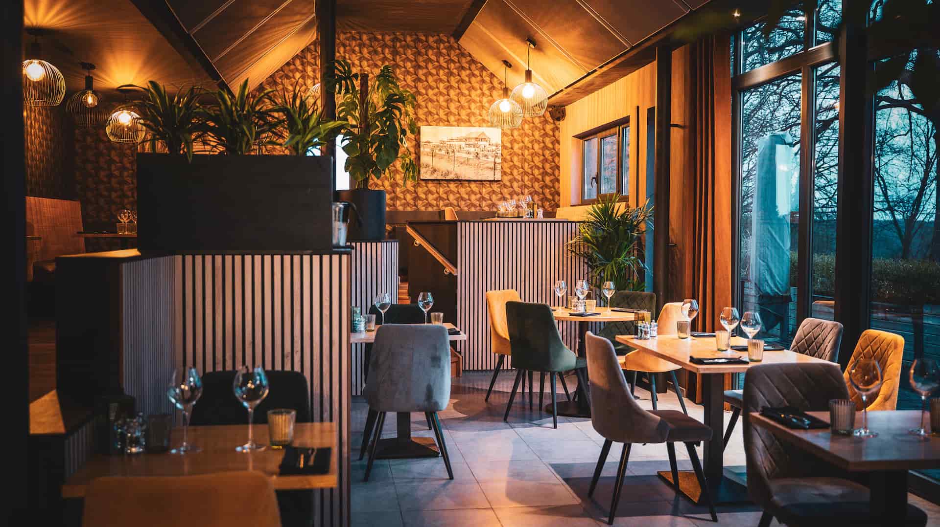 Salle chaleureuse du restaurant L'Entre-Temps à Chimay, tables dressées pour un repas gastronomique de terroi