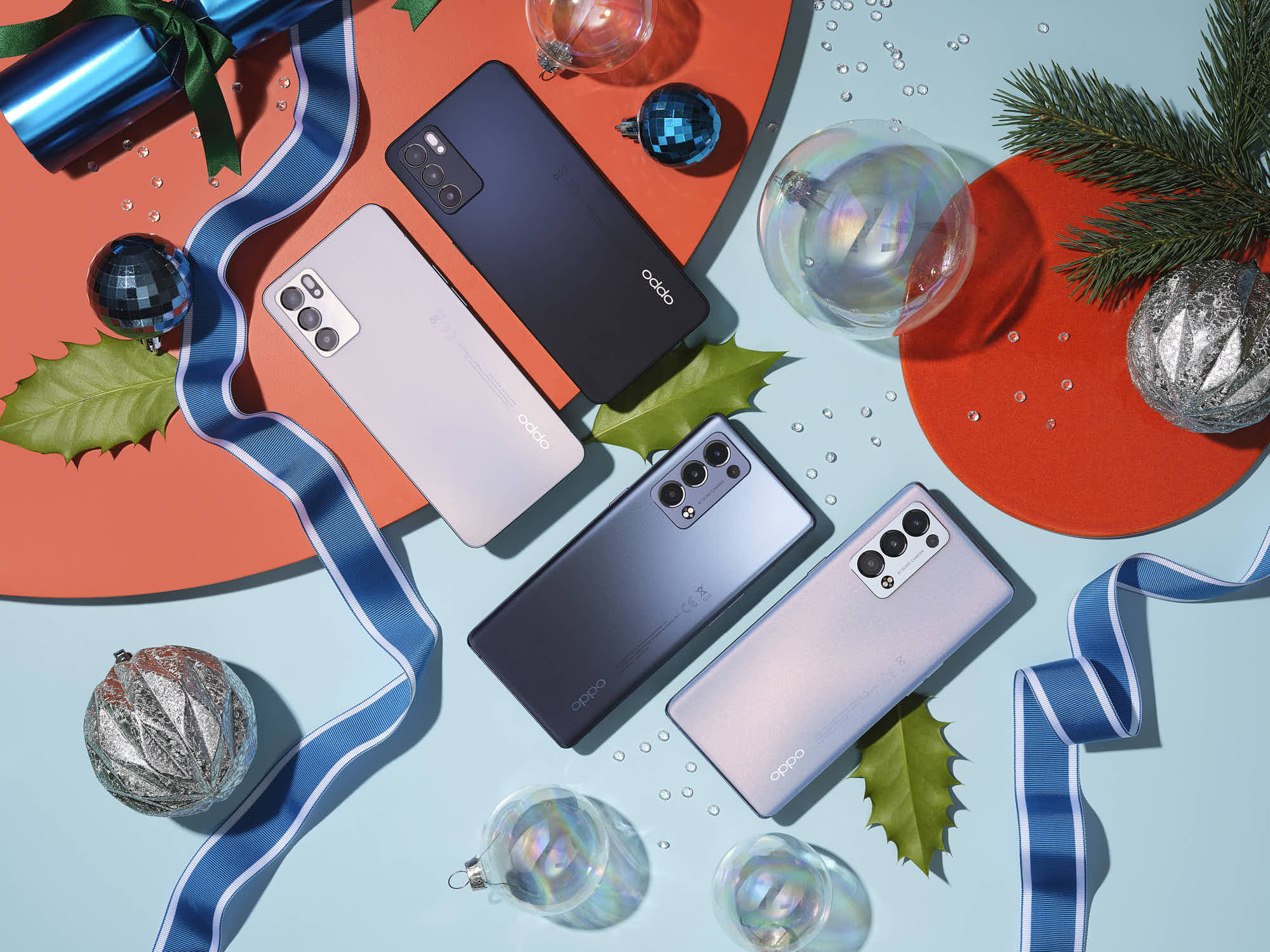 Oppo smartphones on holiday-themed background with decorations and ribbon.