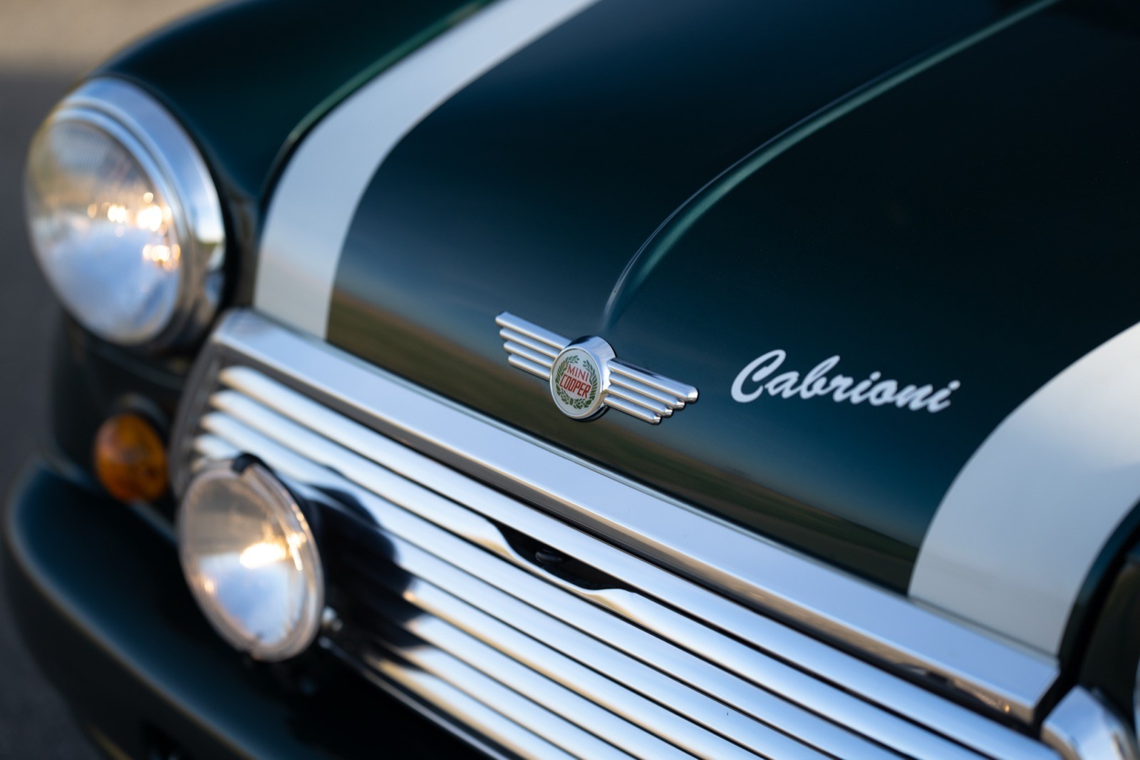 Close-up of a vintage car's hood, featuring the brand name "Triumph" and classic design elements.